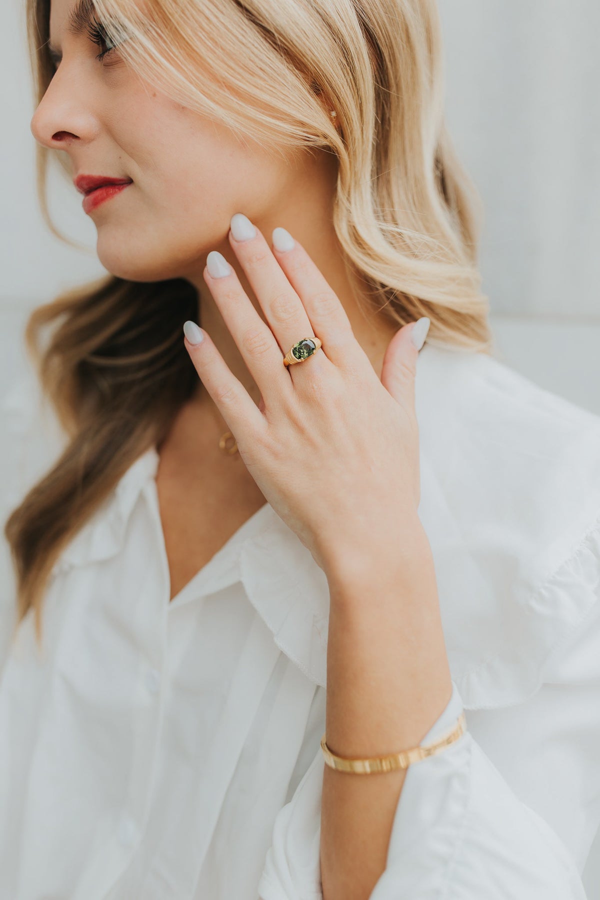Multiple angle shots of the Maddie ring highlighting the oval green stone, ribbed band, and bezel protection.