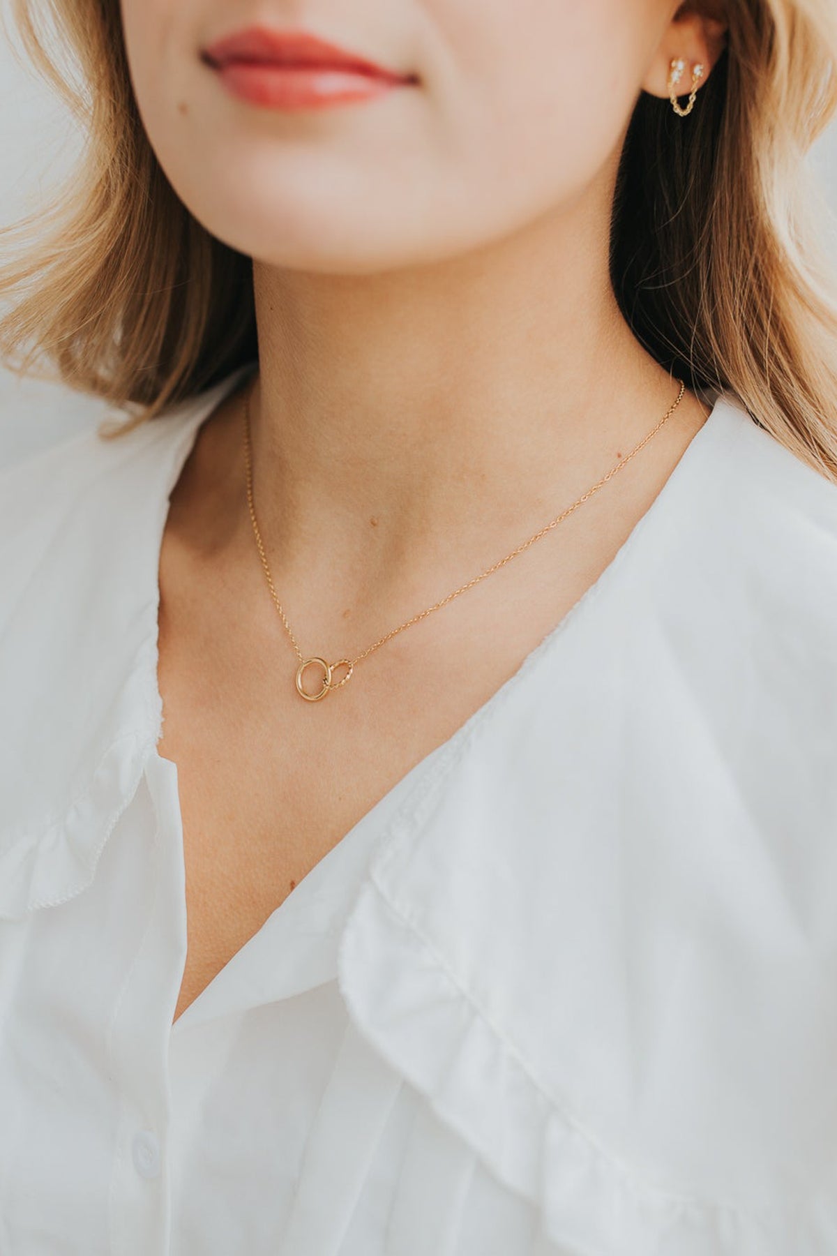 Studio shot of The Mia Necklace on a neutral background, focusing on the textured circle and delicate chain details.