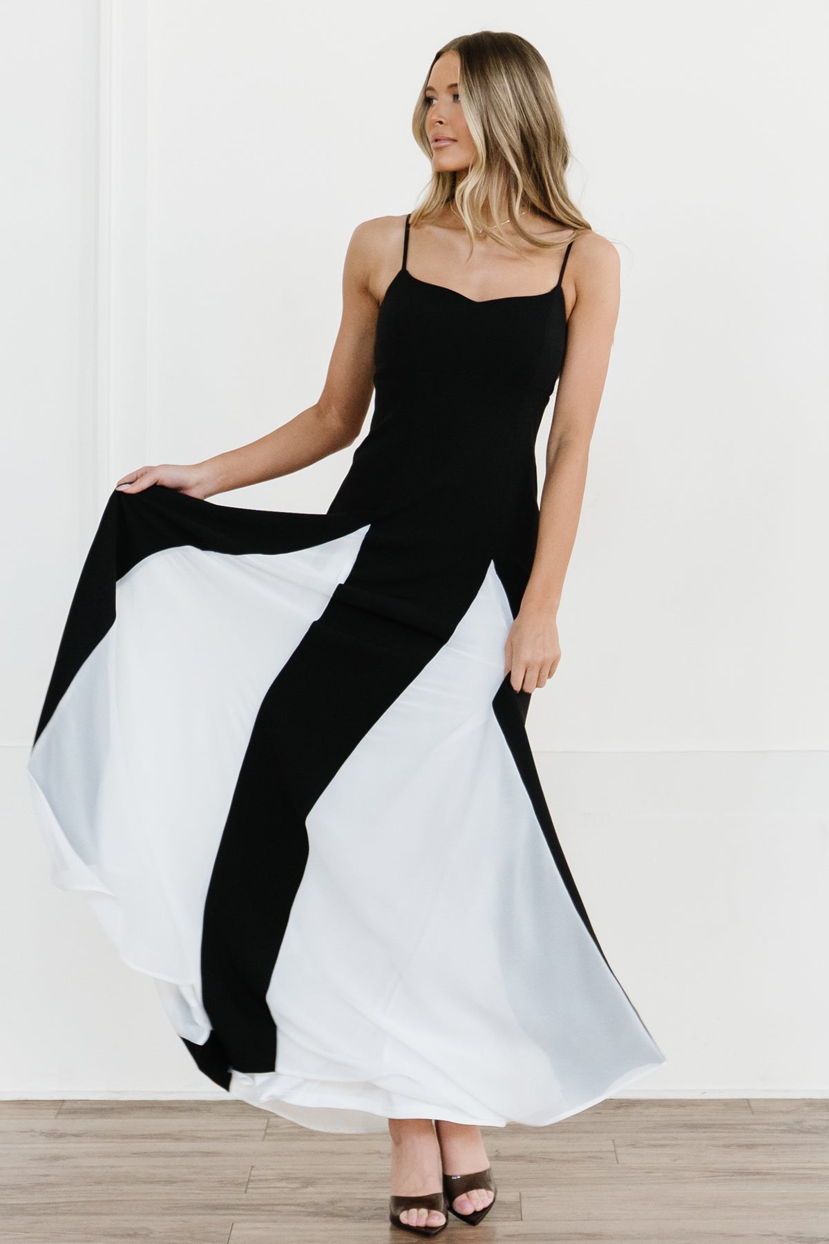 Studio shot of Adela black and white maxi dress on mannequin, fully lined with elegant godet detail at skirt.