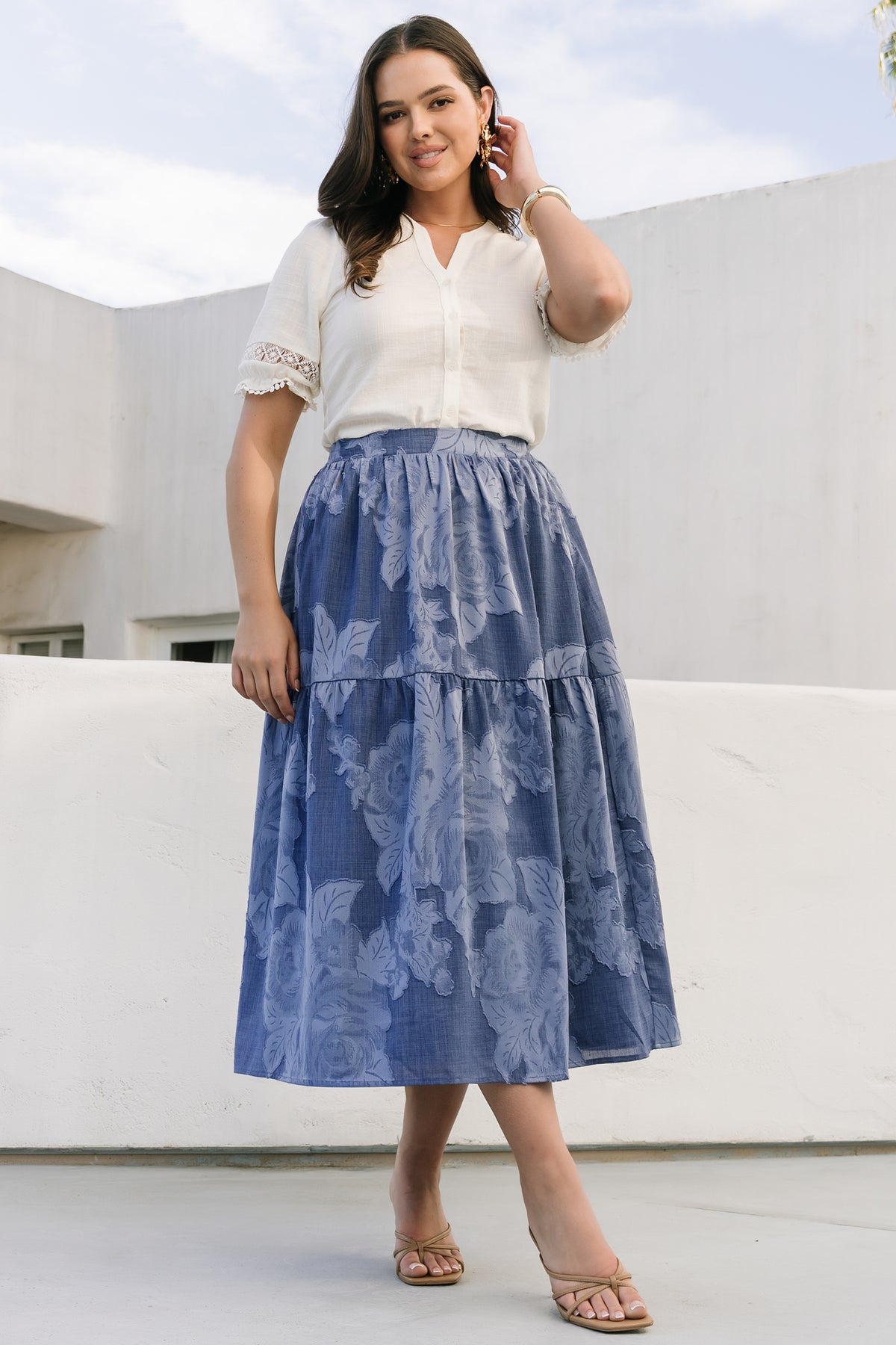 Model wearing the Alba Button Up Top in ivory paired with a skirt, illustrating fit at the shoulders, short sleeve detail, and overall length for styling reference.