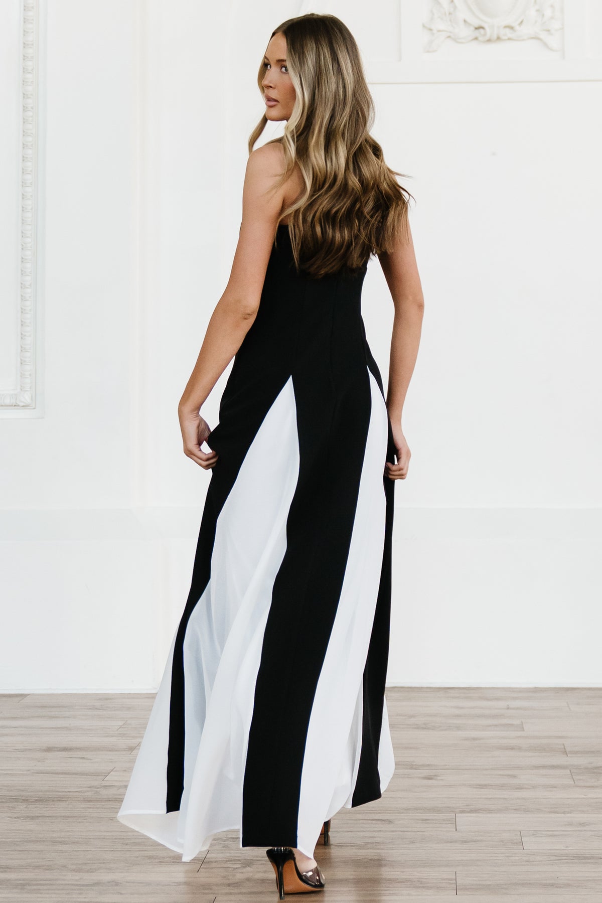 Side view of Adela maxi dress highlighting white chiffon godet panels and the floor-length silhouette in motion.