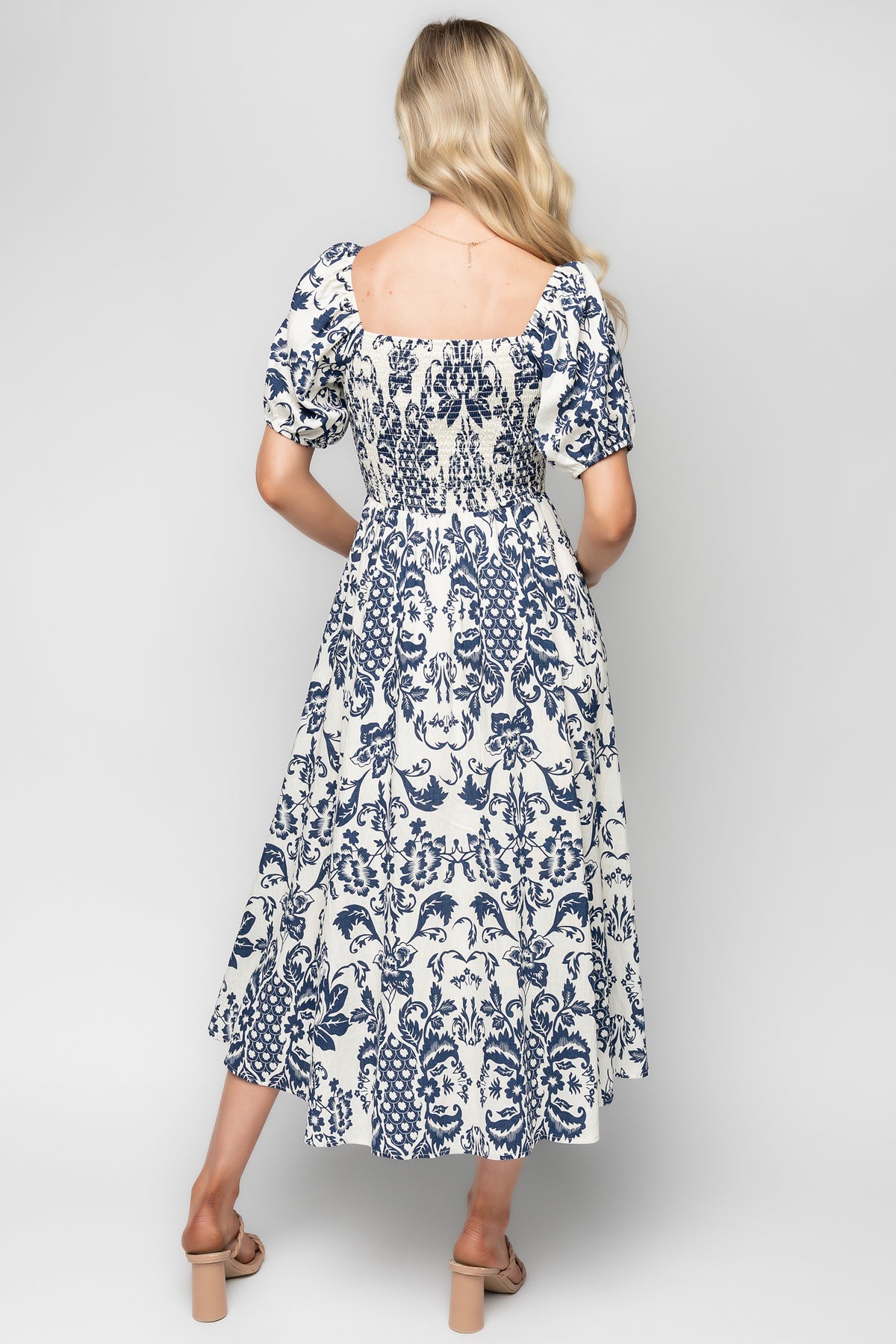 Close-up of the oversized sleeve and elastic cuff on the ivory and navy floral dress, showing sleeve shape and cuff detail with fabric texture.