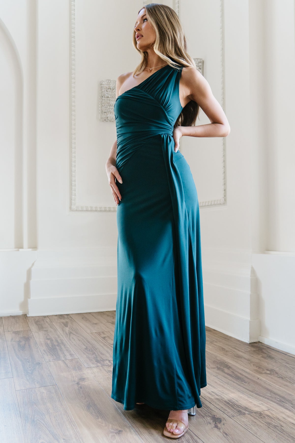 Back view of Adrianna deep topaz gown on model showing one-shoulder closure and smooth skirt line with subtle drape.