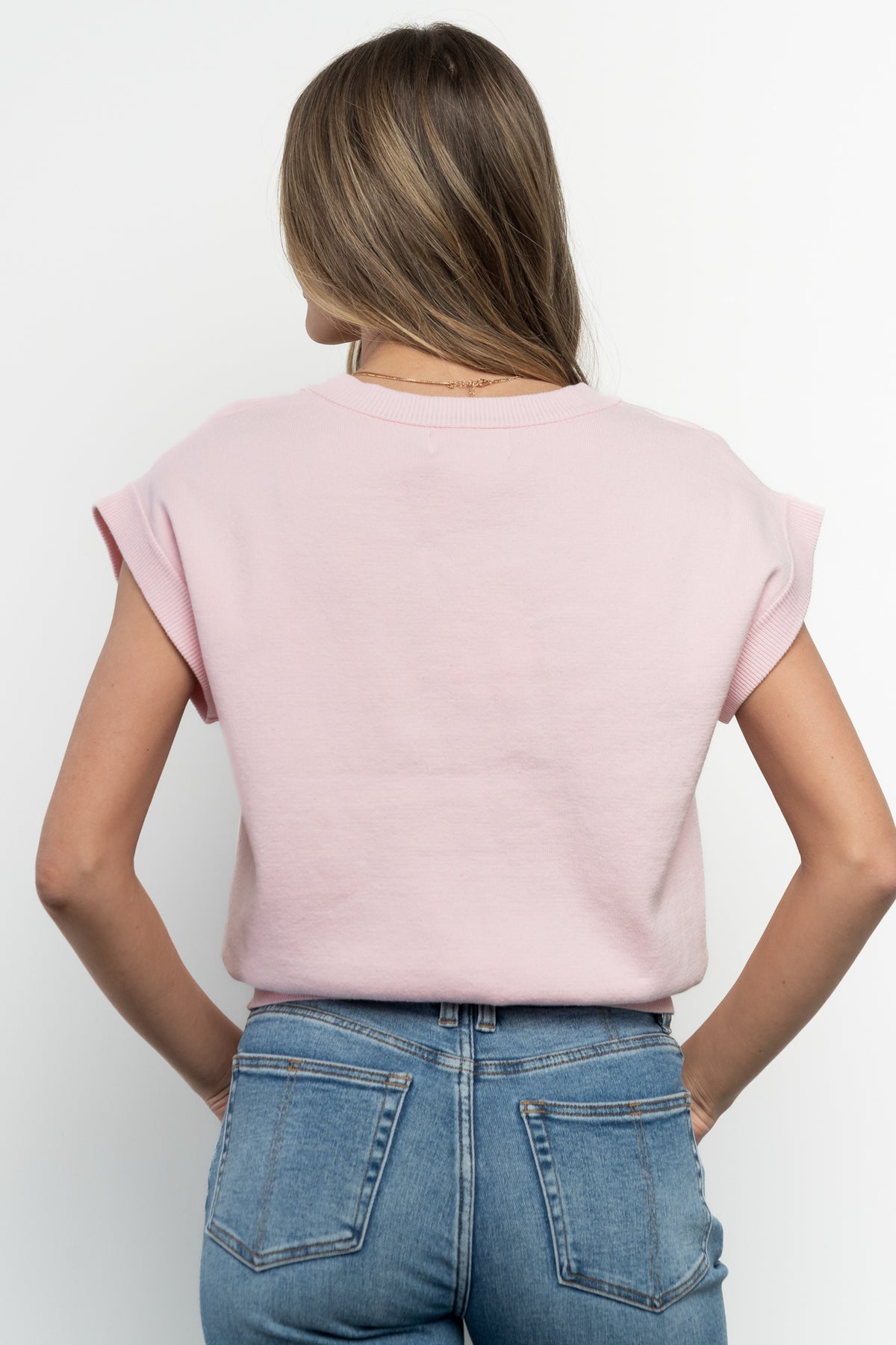 Back view of Lily cardigan on model showing smooth knit back, slightly cinched hem and lightweight silhouette.