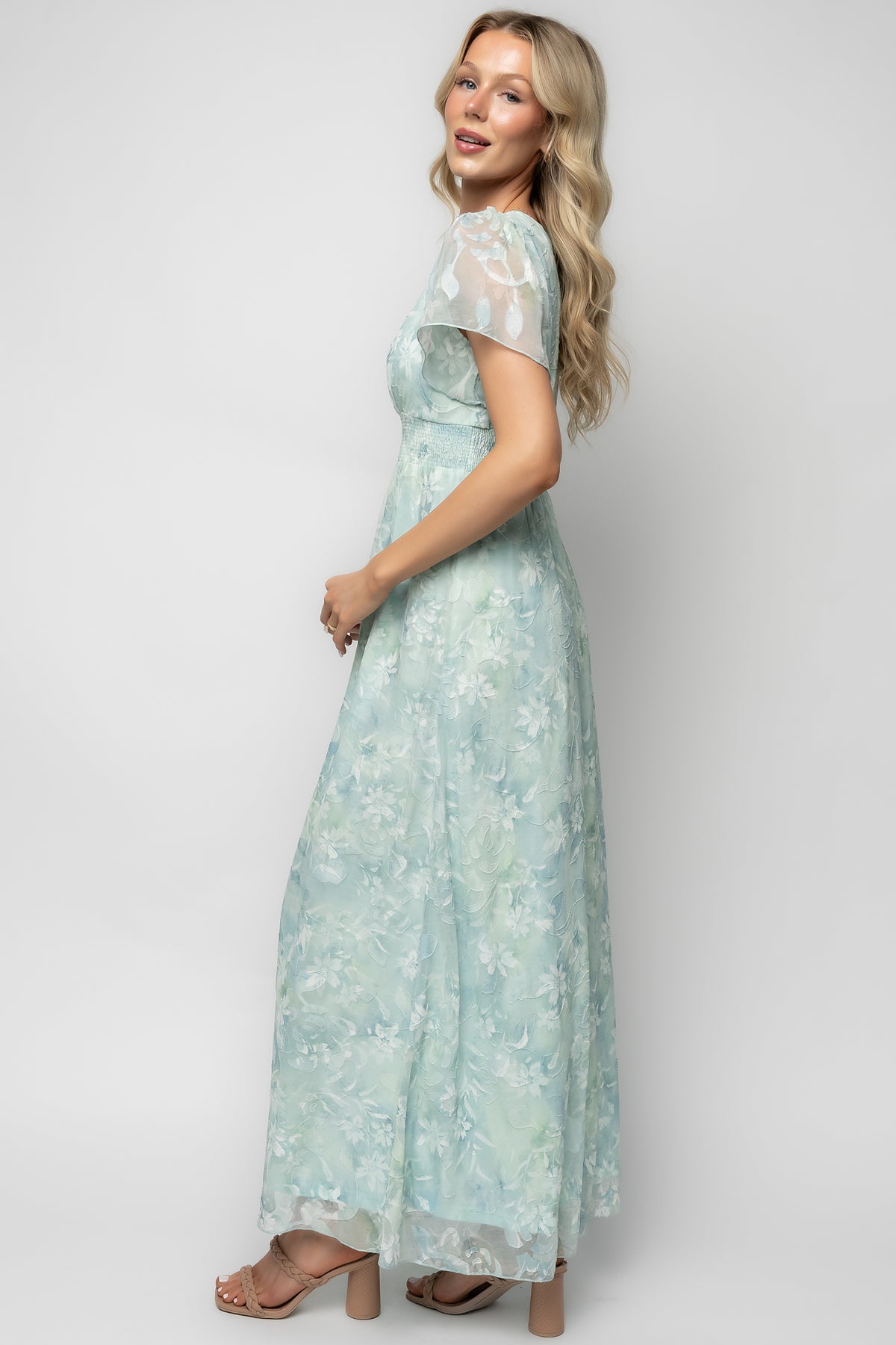 Fabric detail of light teal floral print with burnout velvet overlay and lightweight chiffon drape, showing texture and pattern close-up.