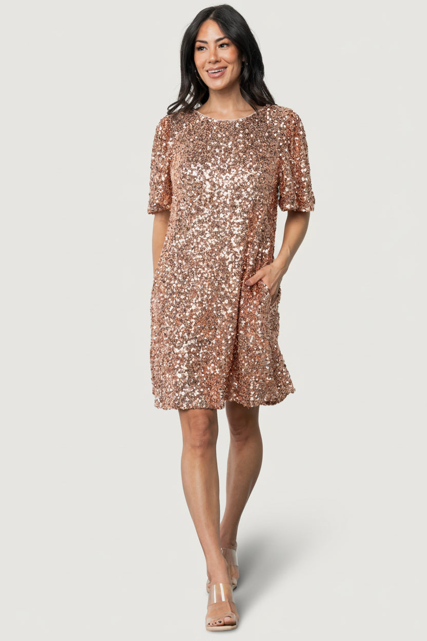 Front view of Asta sequin shift dress in rose gold on model, showing round neckline, short sleeves, and hidden side pockets.