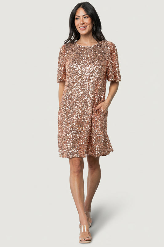 Front view of Asta sequin shift dress in rose gold on model, showing round neckline, short sleeves, and hidden side pockets.