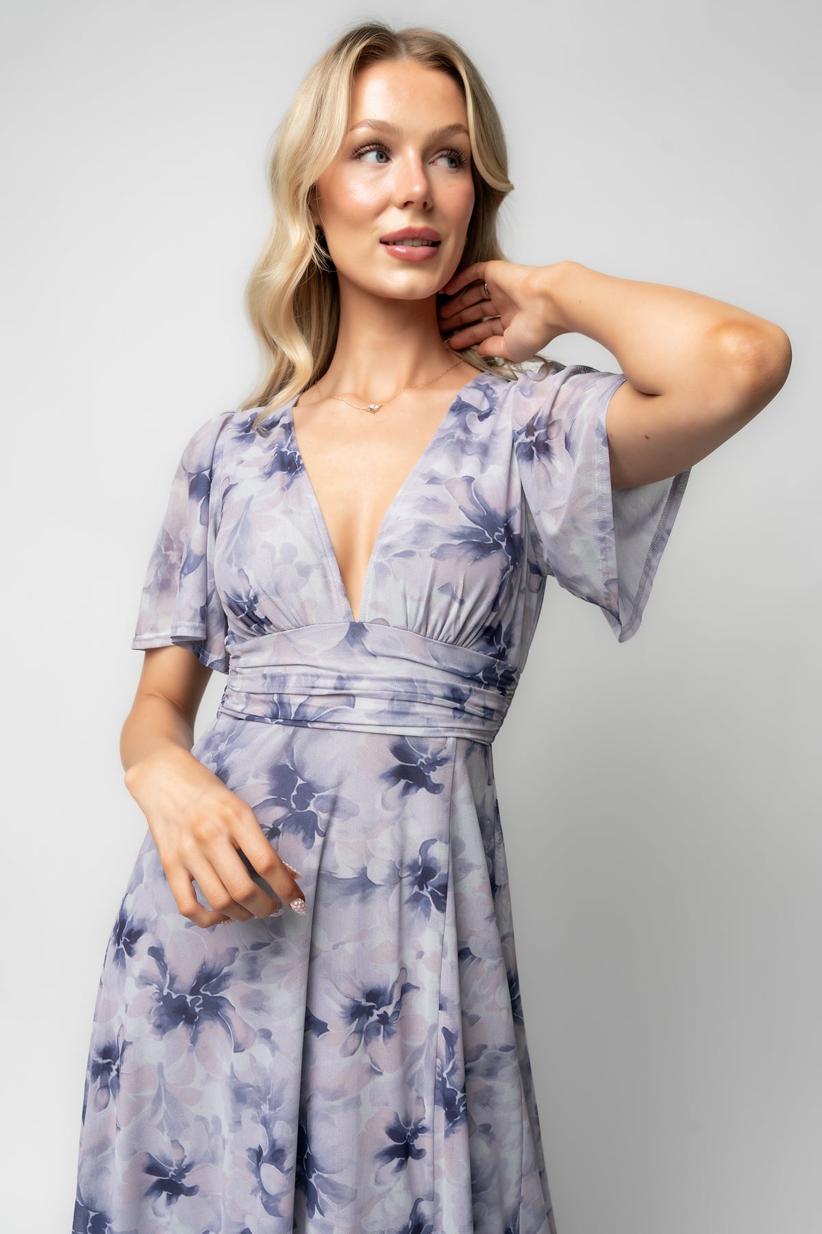 Back view highlighting banded empire waist with elastic back, gentle gathering at the waistline, and the smooth lined skirt silhouette.