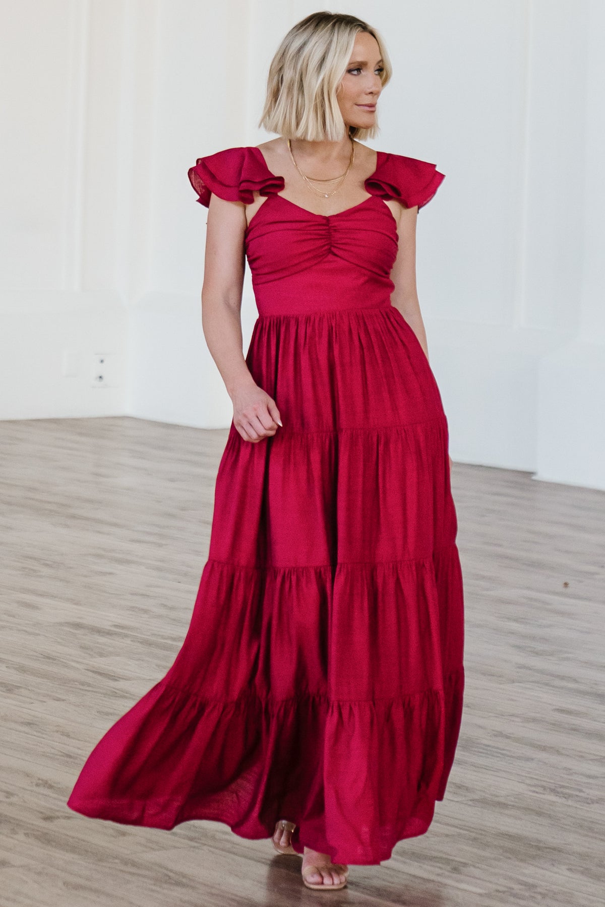 Close-up of the Vivianne Maxi Dress sleeve and neckline detailing in deep red, showing elastic at shoulder and soft fabric texture.