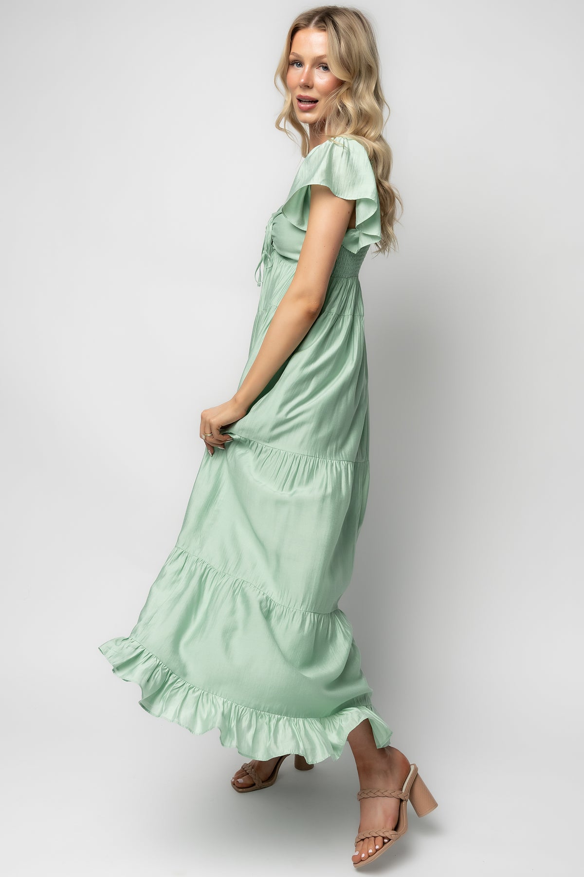 Detail shot of Agatha Maxi Dress light sage fabric and finish showing ruffle trim, seam detail, and smooth lining inside the bodice and skirt.