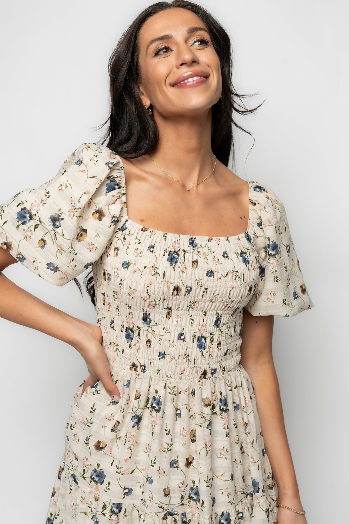Detail shot of textured crepe fabric and print on beige floral Mattea dress, emphasizing pattern, drape, and fabric finish.