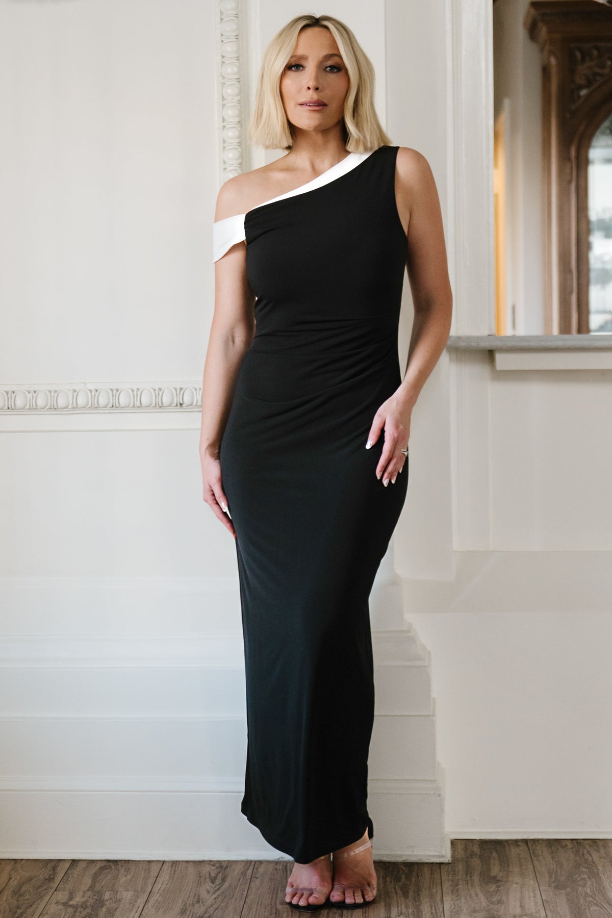 Close-up of neckline and sleeve showing ivory trim detail and luxe knit texture with stretch composition for comfortable wear.