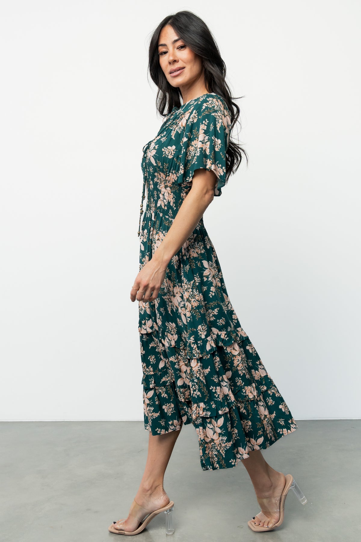 Model styling shot of the Topaz and blush floral midi dress paired with accessories, showing overall silhouette and occasion-ready look.