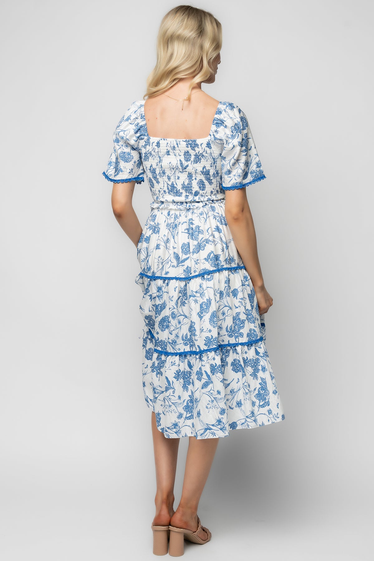 Back and side view of the Freya dress showing puffed elastic sleeves, unlined sleeve detail, and the tiered skirt movement.