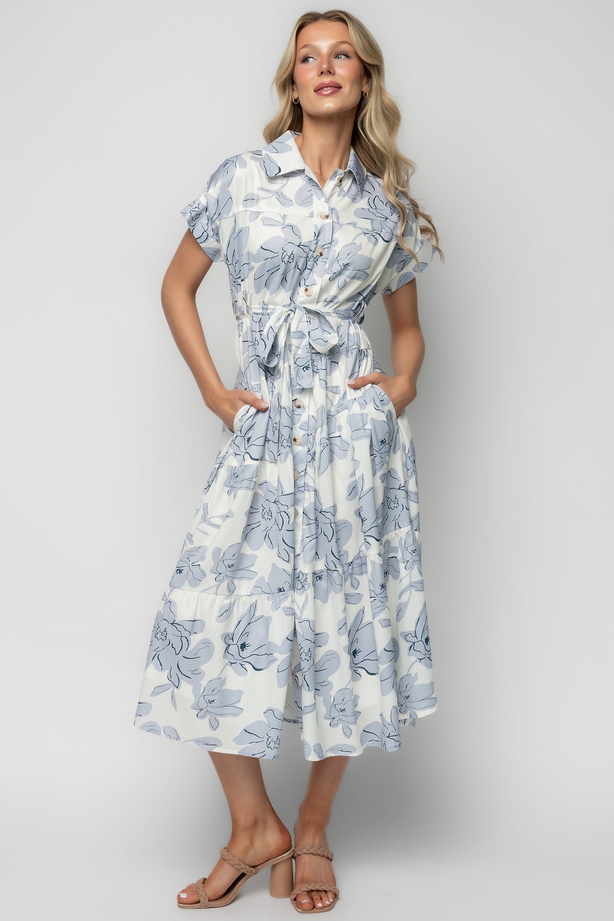 Close-up of bodice and functional button-front showing ivory fabric with delicate blue and navy floral pattern and short sleeve detail.