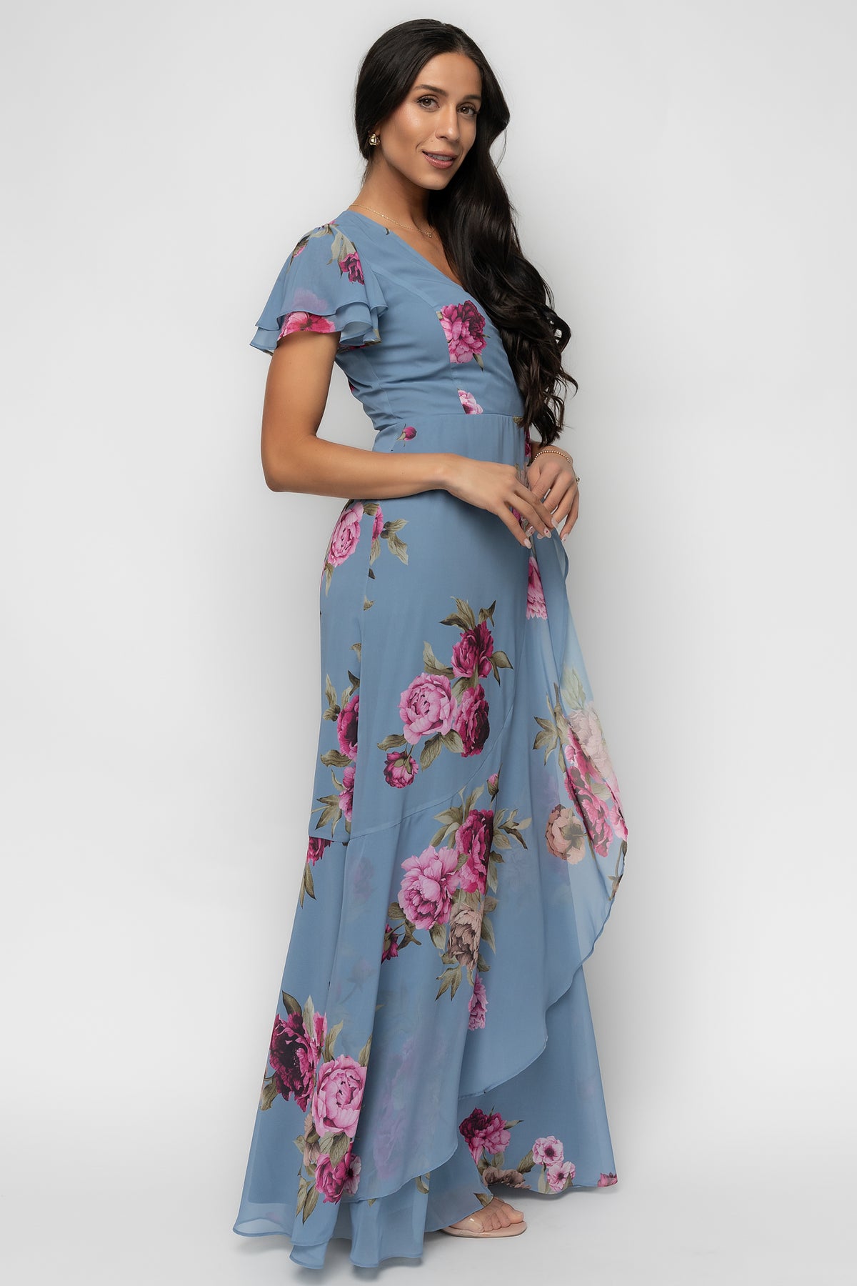Model wearing the Willa Maxi Dress at an angle to show movement, A-line silhouette, and lightweight chiffon construction in slate blue floral.