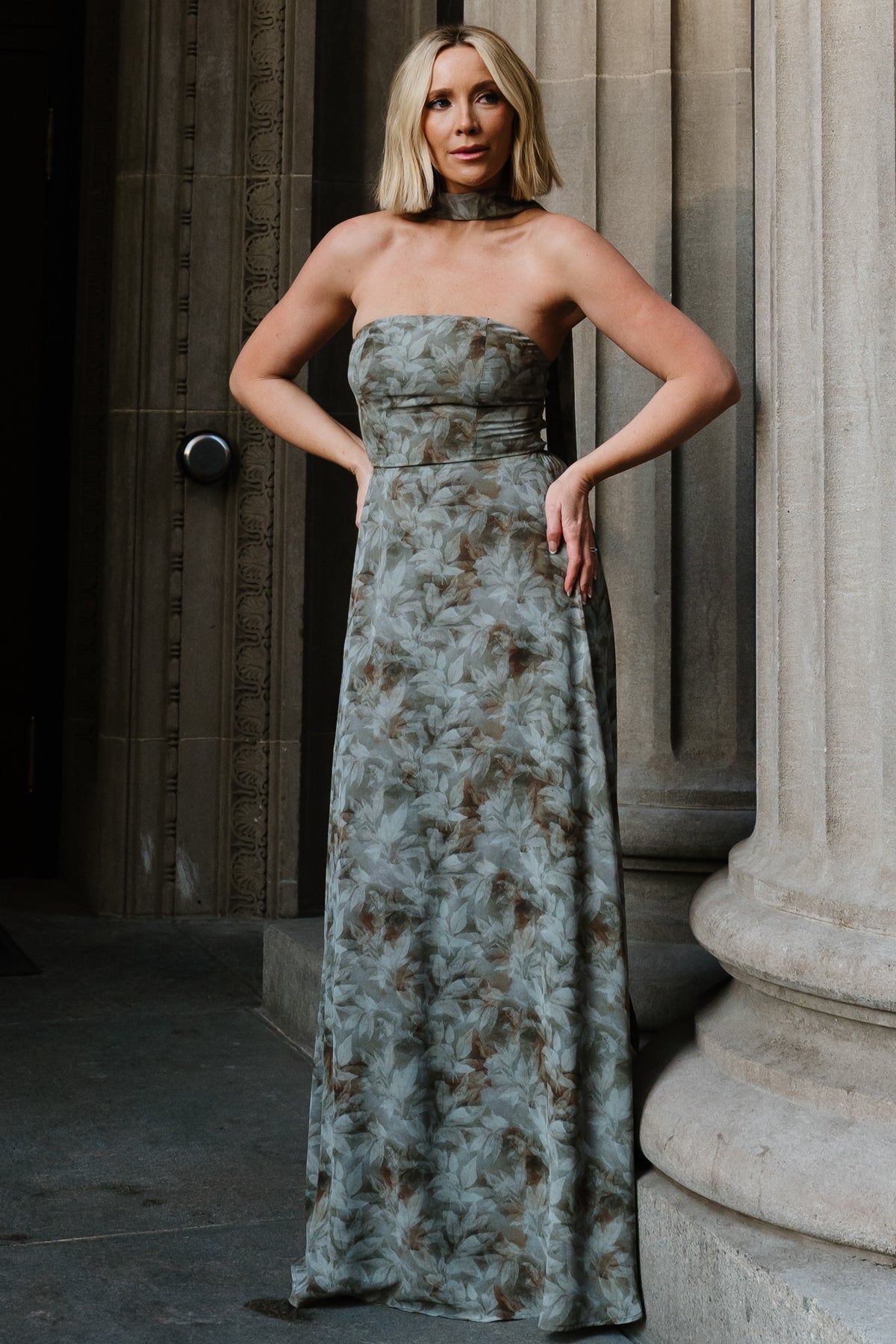 Front full-length view of model wearing Florian strapless maxi dress in eucalyptus green floral chiffon, showing fitted bodice and flowing skirt.