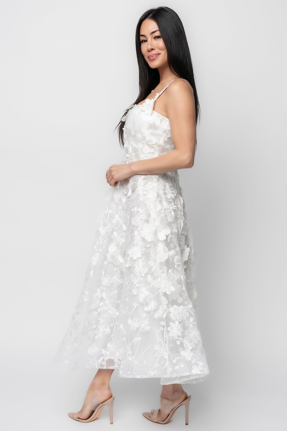 Close-up of delicate floral appliqué on ivory mesh fabric with visible stitching and texture detail.