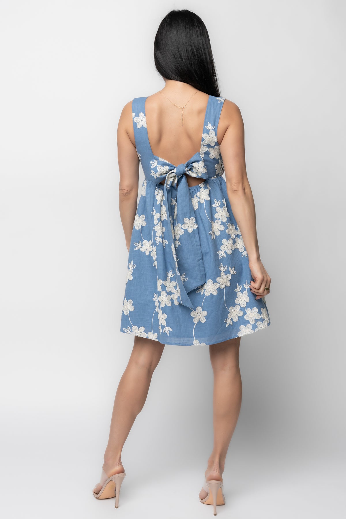 Close-up of off-white floral embroidery and cotton fabric texture on the Ivy Short Dress, showing stitch detail and material contrast.