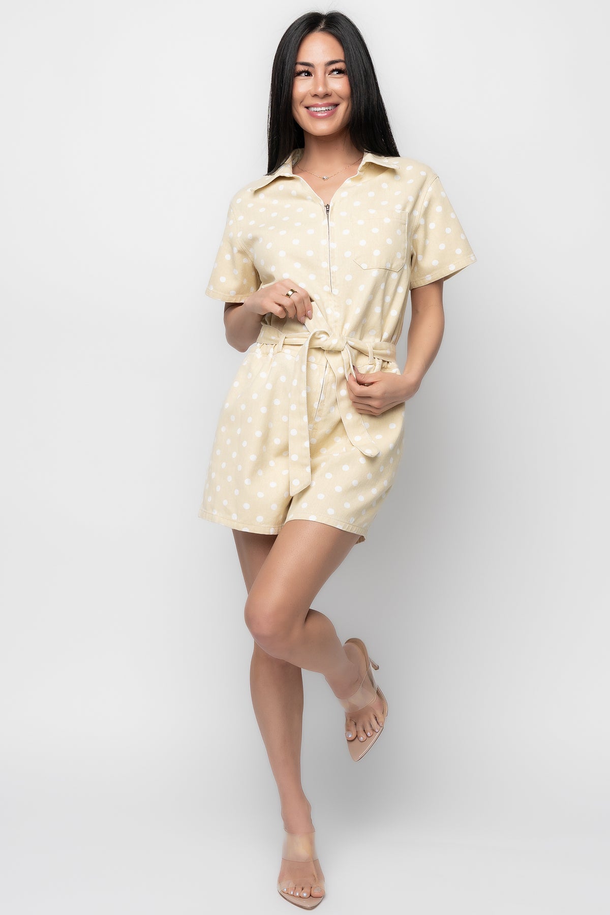 Front view of Korra zip-up romper in light yellow twill with white polka dots, showing collared neckline, chest pocket, and functional zipper.