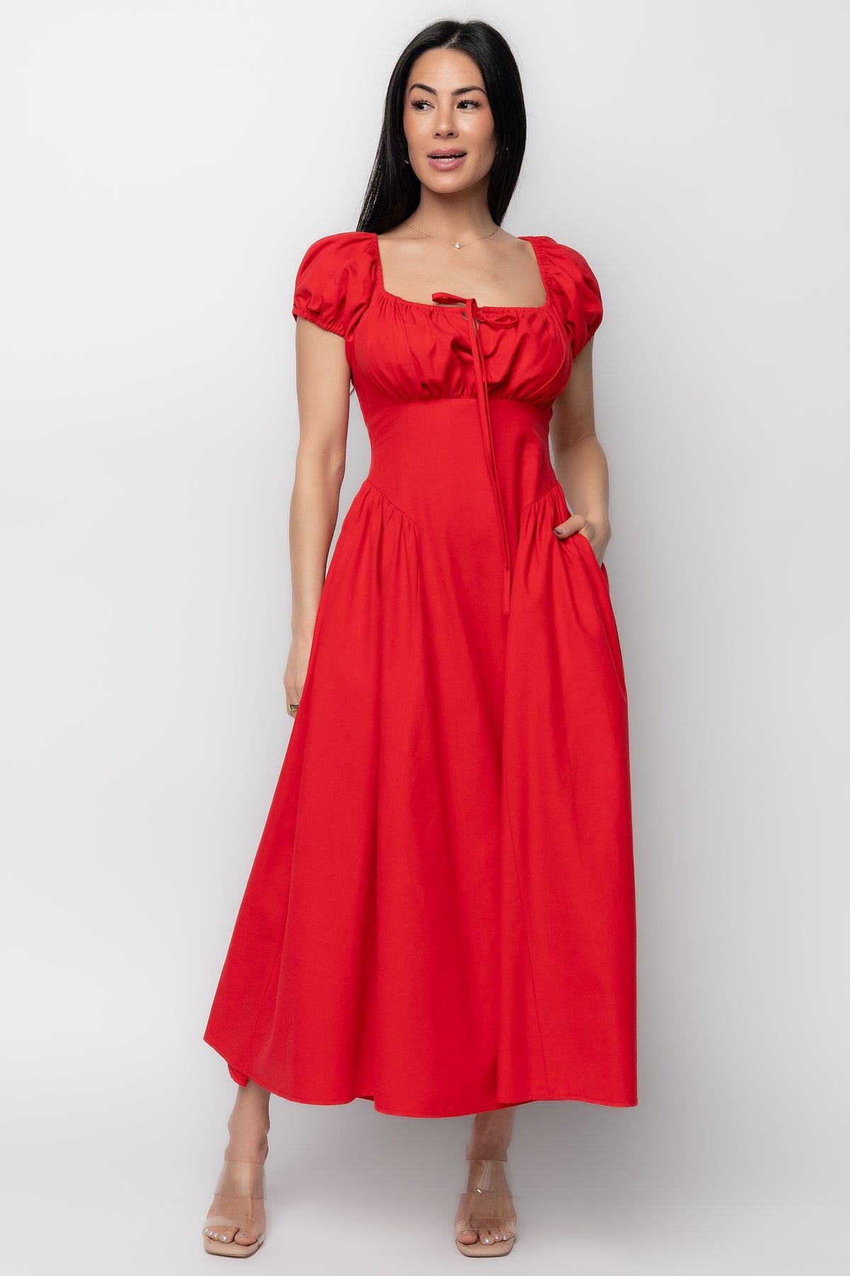 Front view of red Havana midi dress showing square neckline, short bubble sleeves, descending point panel and pleated hips.