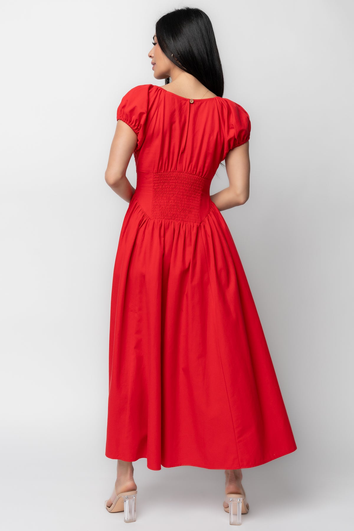 Side view of the red midi dress showing the hidden side pocket placement and the descending point panel above the waist.