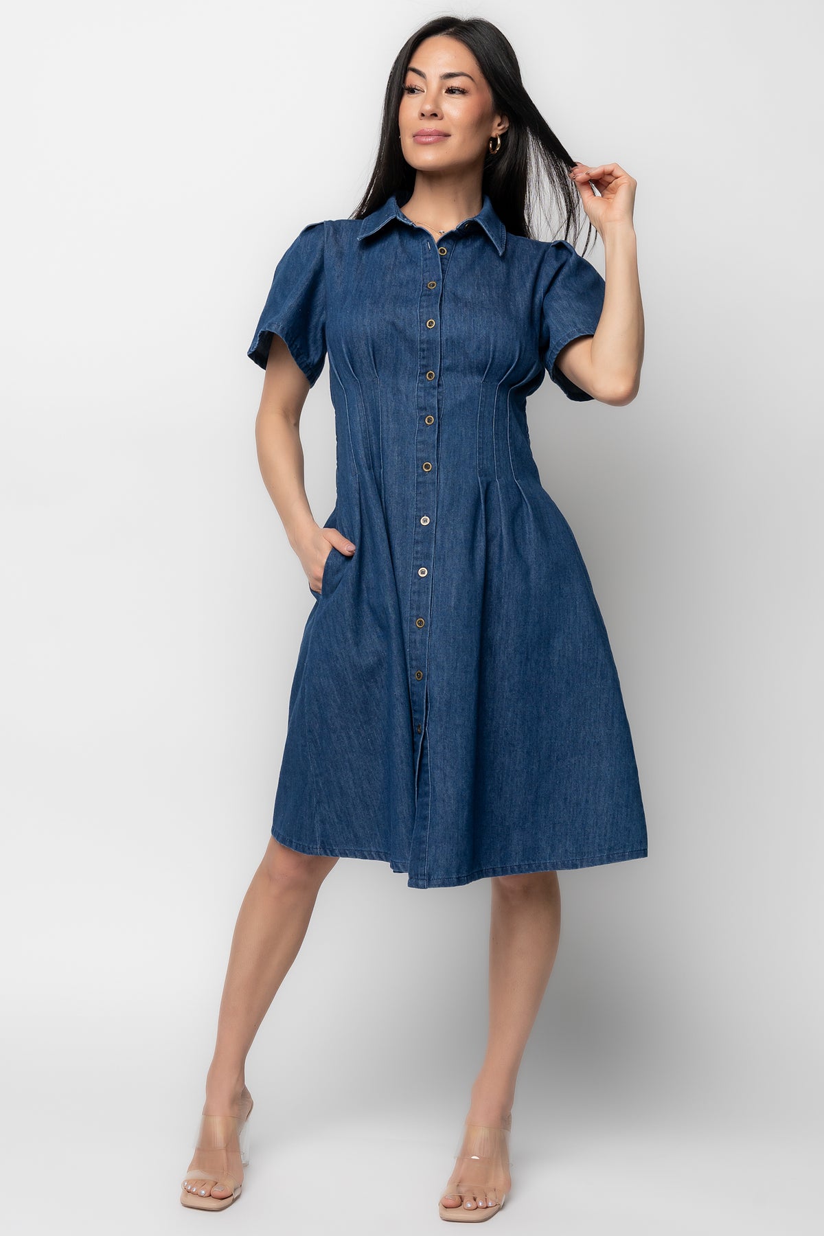 Front view of model wearing dark blue Coco denim short dress with collared neckline, button-front and side pockets, styled with casual shoes.