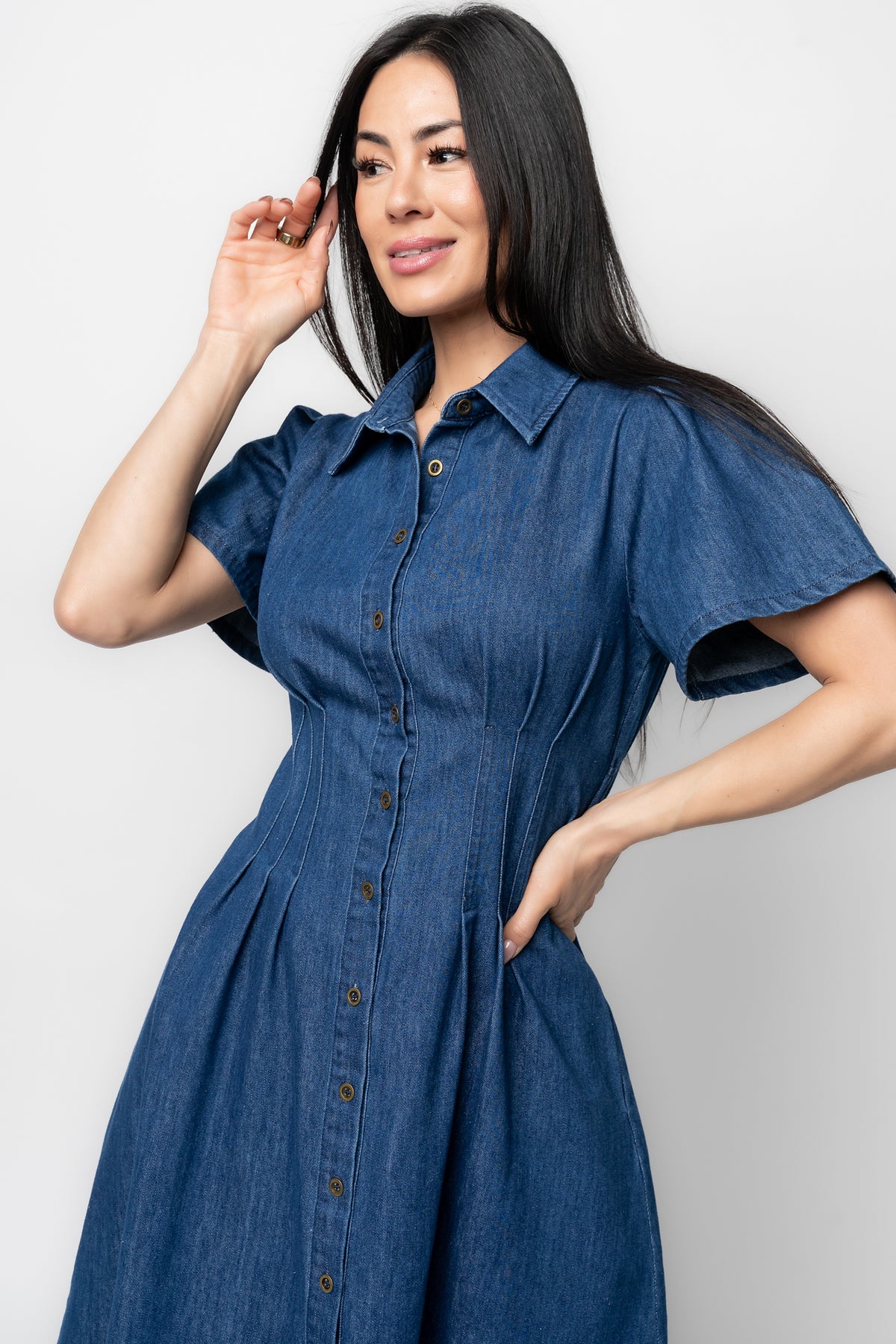 Side profile of the Coco Denim Short Dress showing functional side pockets and the relaxed short sleeve silhouette in dark blue denim.