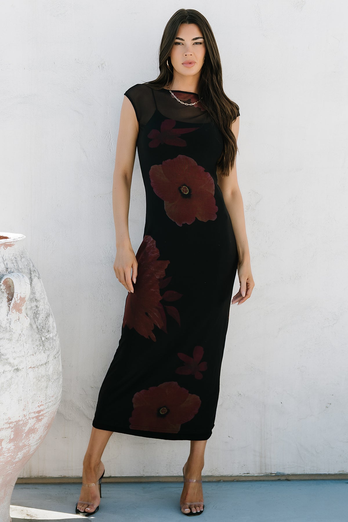 Rear and side view of Daniela dress showing mesh overlay drape, fitted bodycon shape, and maroon floral placement on black base.