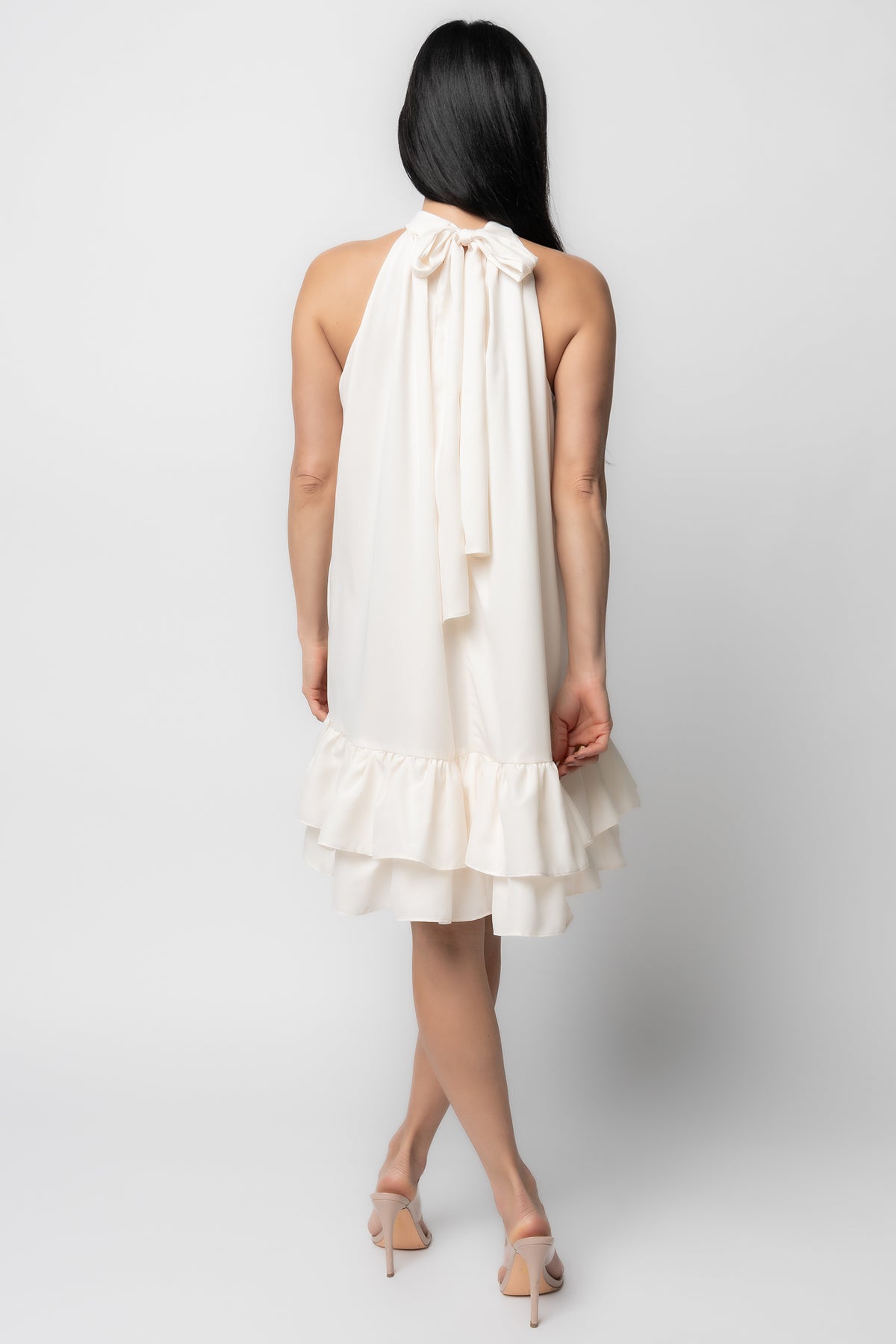 Detail close-up of the fabric and ruffle edge on the Lulu halter dress, showing the lightweight satin-like finish and stitching.