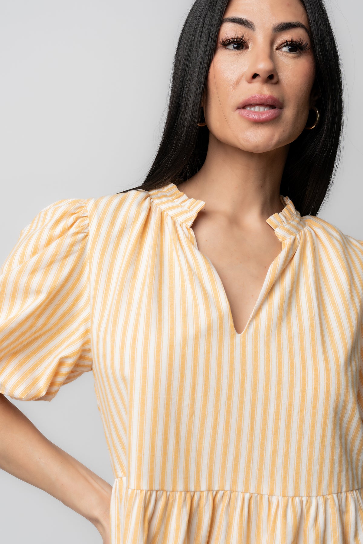 Back view of the Sadie Short Dress in Creamsicle highlighting the tiered skirt, gathered waist, and short balloon sleeves for feminine movement.