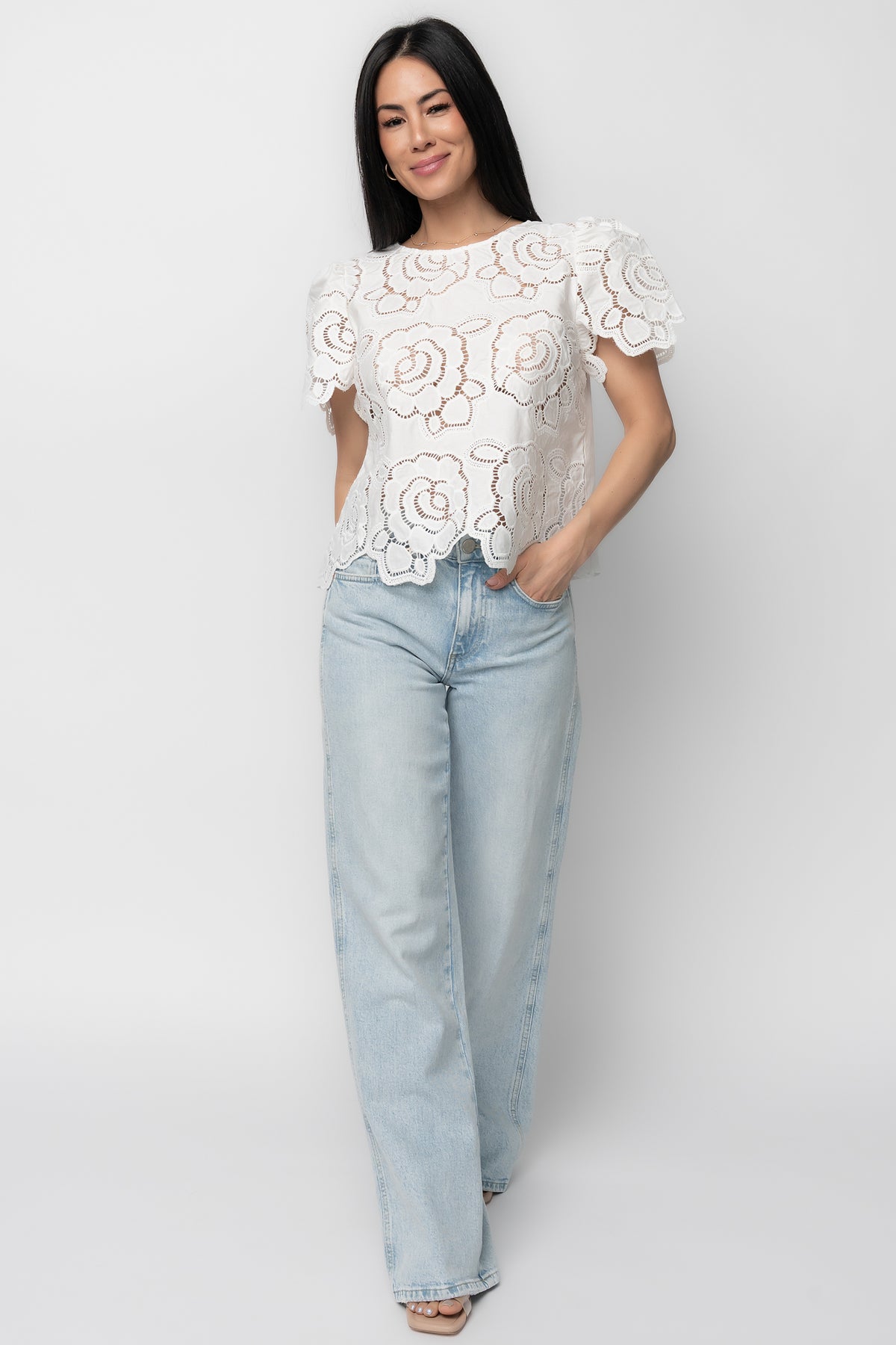 Styled outfit photo of Delphine Floral Top with mid-rise relaxed jeans, highlighting the top's texture, embroidered eyelet detail, and casual styling options.