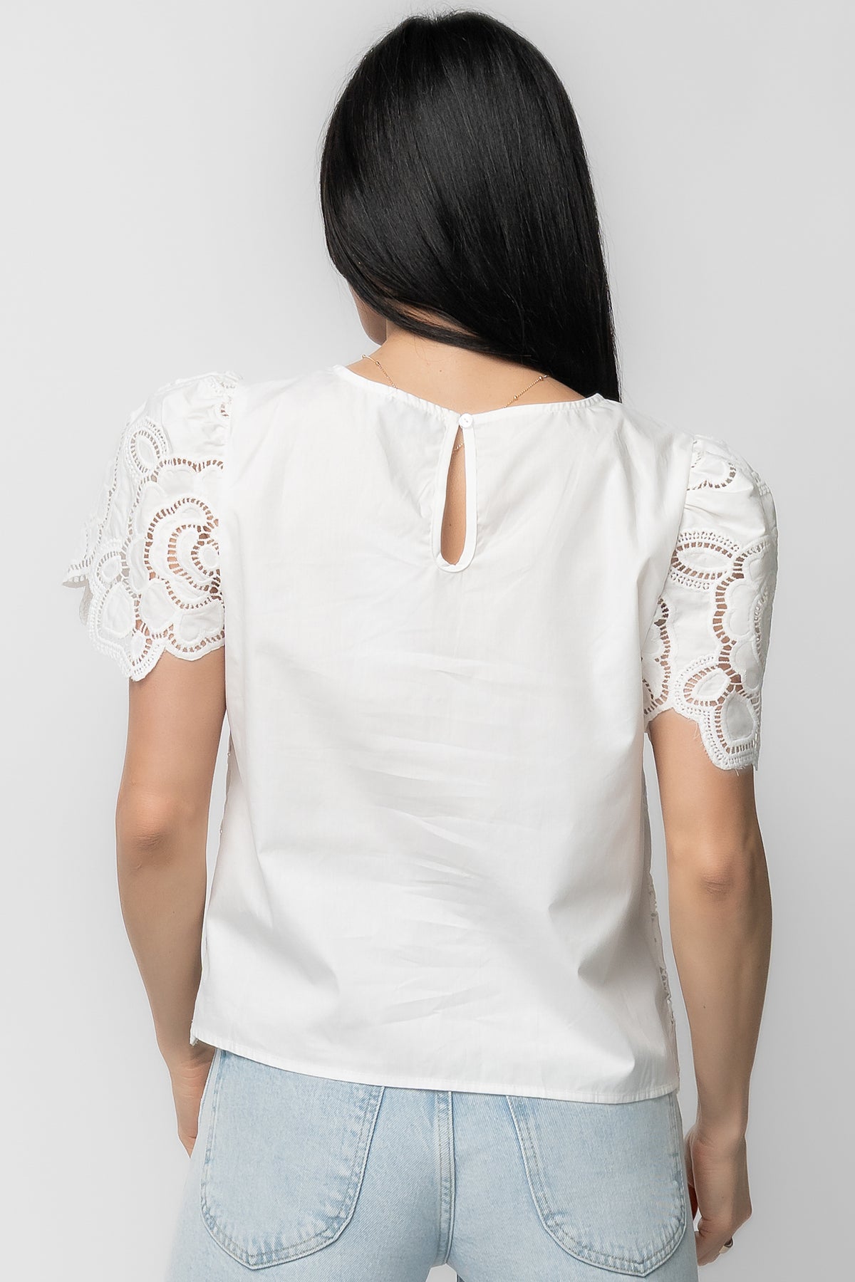 Back and side view of the off-white Delphine Floral Top on model, showing short sleeve length, shoulder seam, and overall silhouette.
