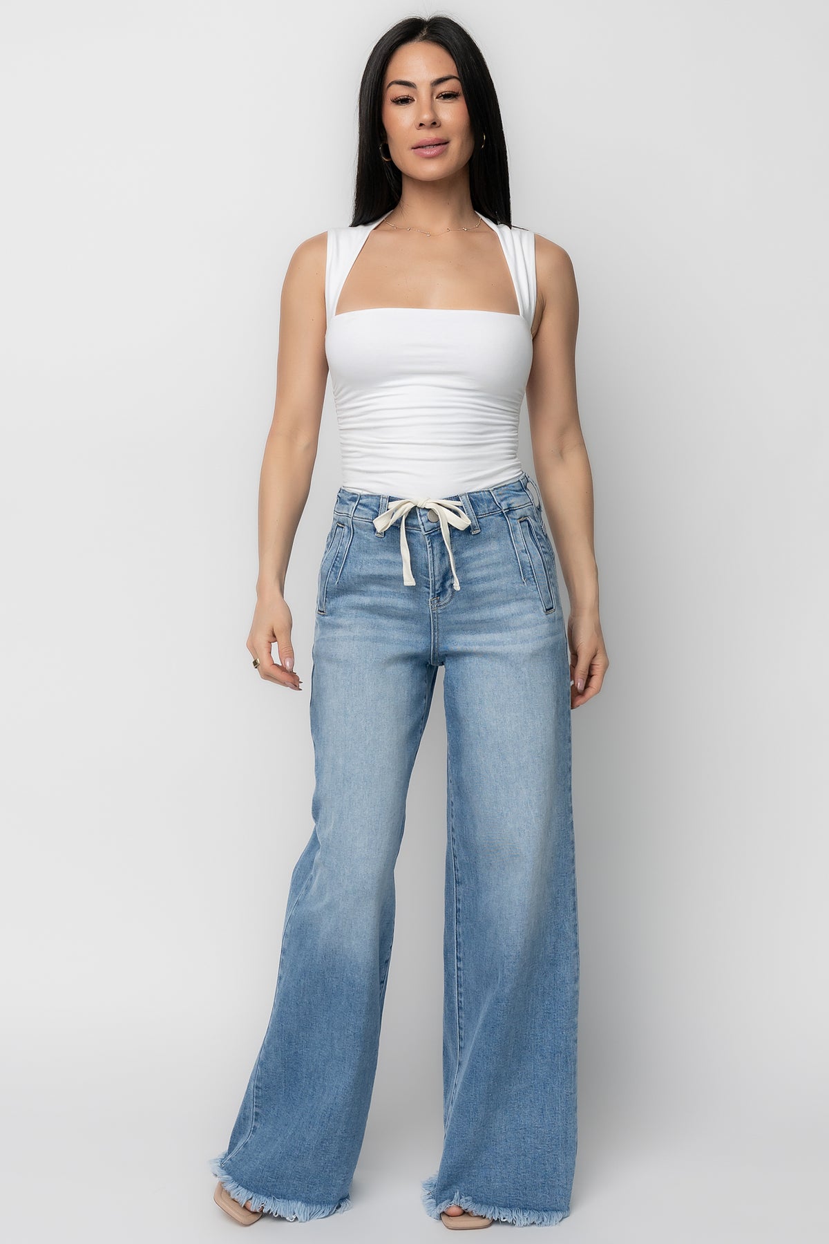 Back view highlighting classic pocket placement and frayed hem on Jardin high-rise wide-leg jeans in a versatile mid wash, relaxed silhouette.