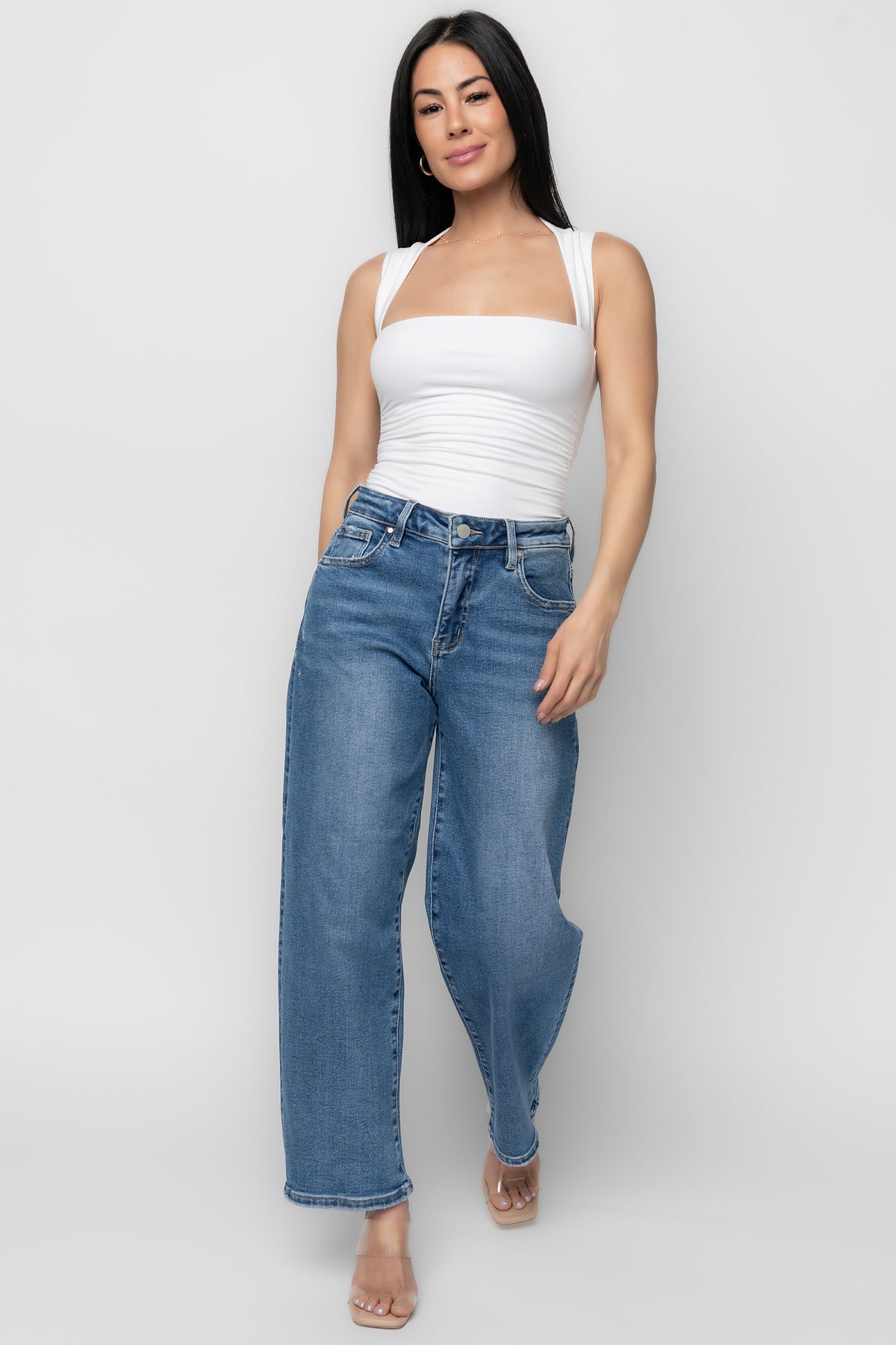 Rear view of Lumi medium-wash jeans on model showing back pockets, distressing detail at rear pockets, and cropped hem that hits above the ankle.