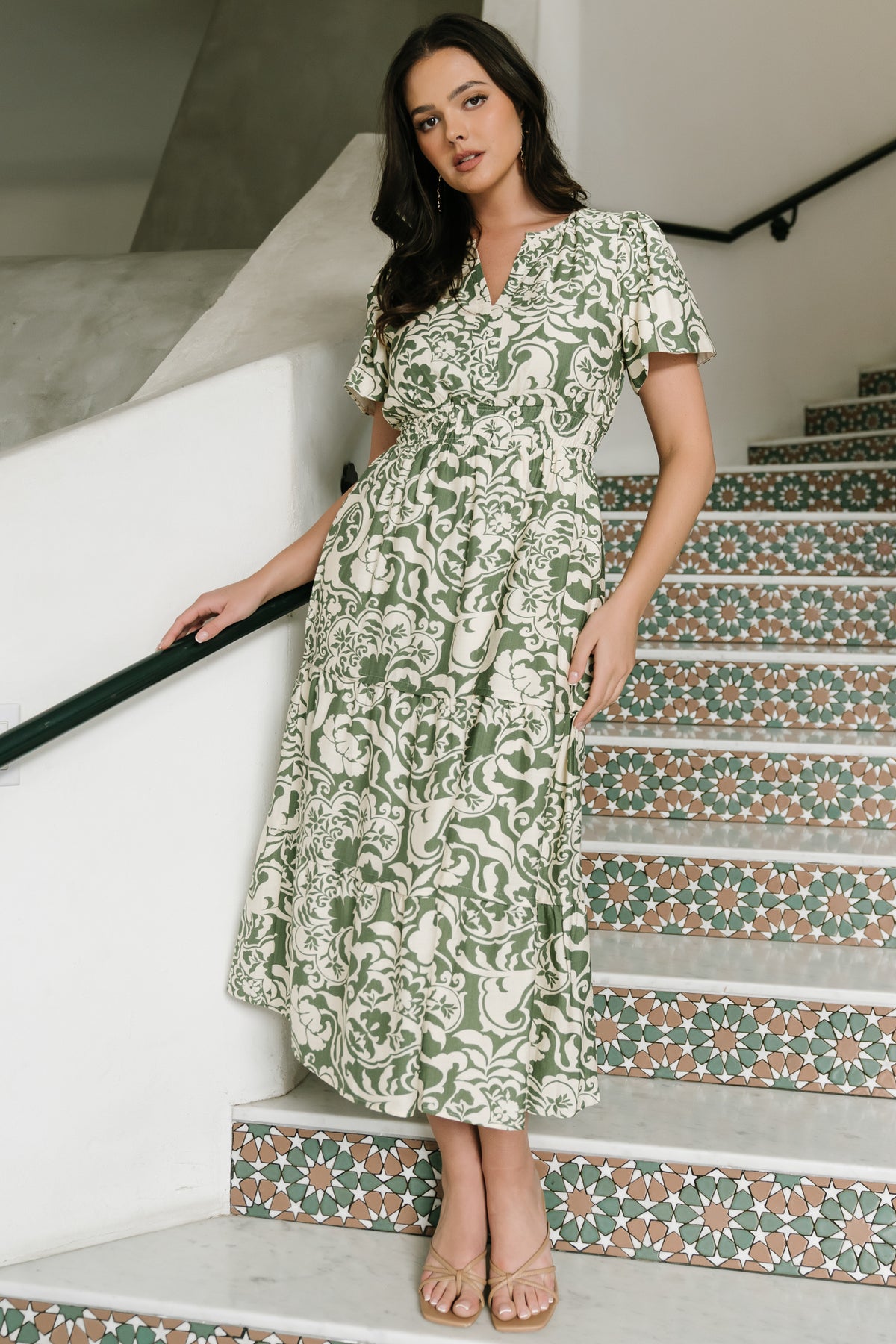 Close-up of fabric and print showing ivory background with green floral motifs and subtle linen-like rayon texture and stitching detail.
