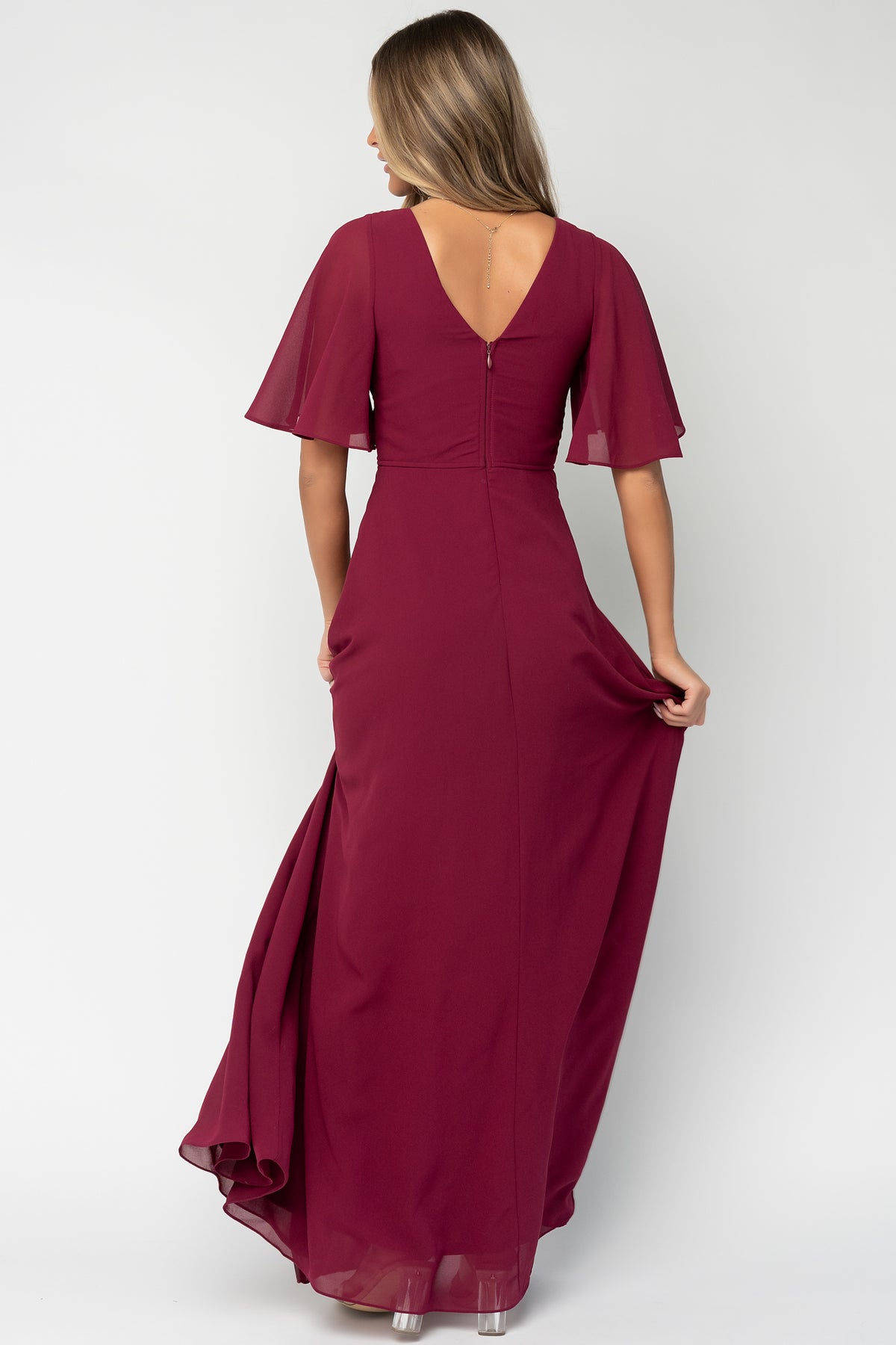 Side view of the wine Valetta Maxi Dress highlighting the left leg slit, soft drape of the chiffon fabric and elegant silhouette.