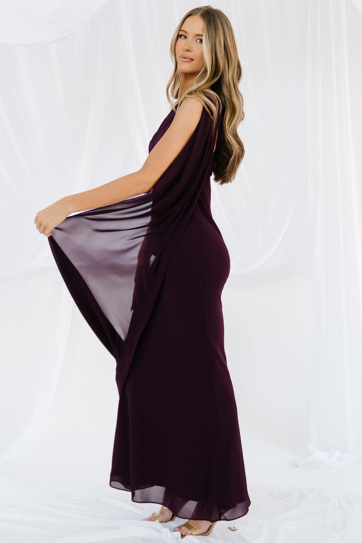 Full-length look at the Julianne dark-plum dress on model, illustrating the maxi skirt length and formal drape.