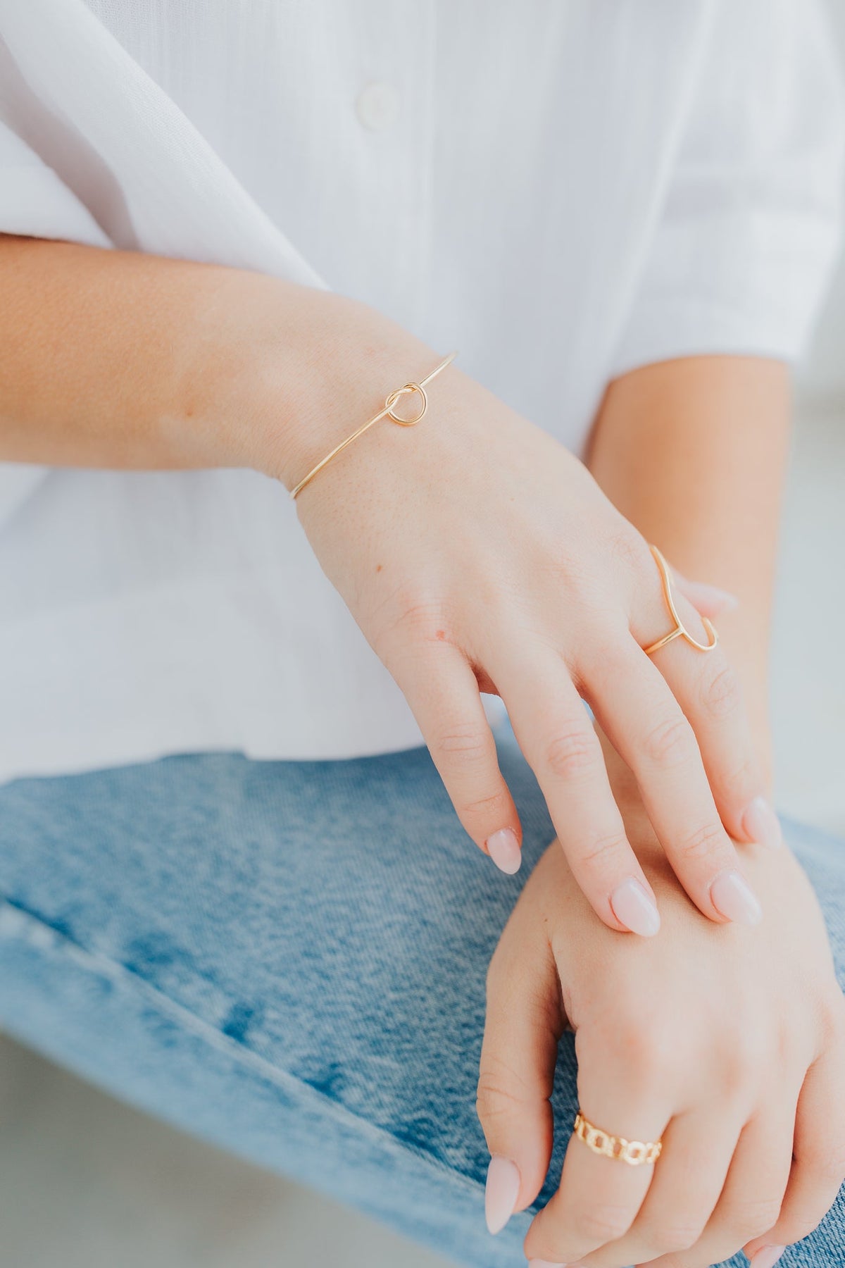 Detailed view of The Kate Bangle knot and band curvature, emphasizing the polished gold finish and lightweight profile for everyday wear.