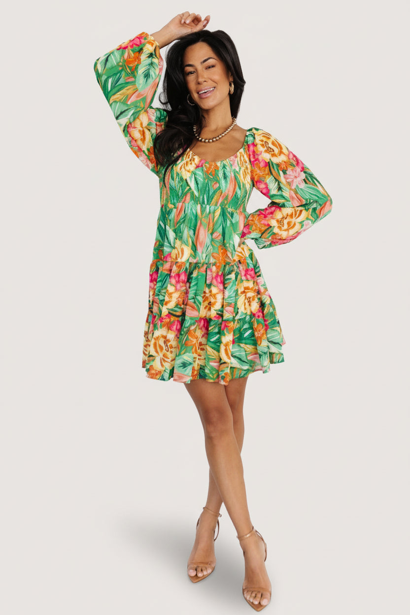 Green multi-print chiffon short dress with smocked bodice, V-neck, long sheer sleeves and tiered ruffle skirt, fully lined for coverage.