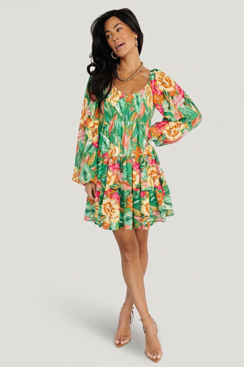 Fabric close-up of green tropical floral print on chiffon shell with visible lining edge and soft drape for summer wear.