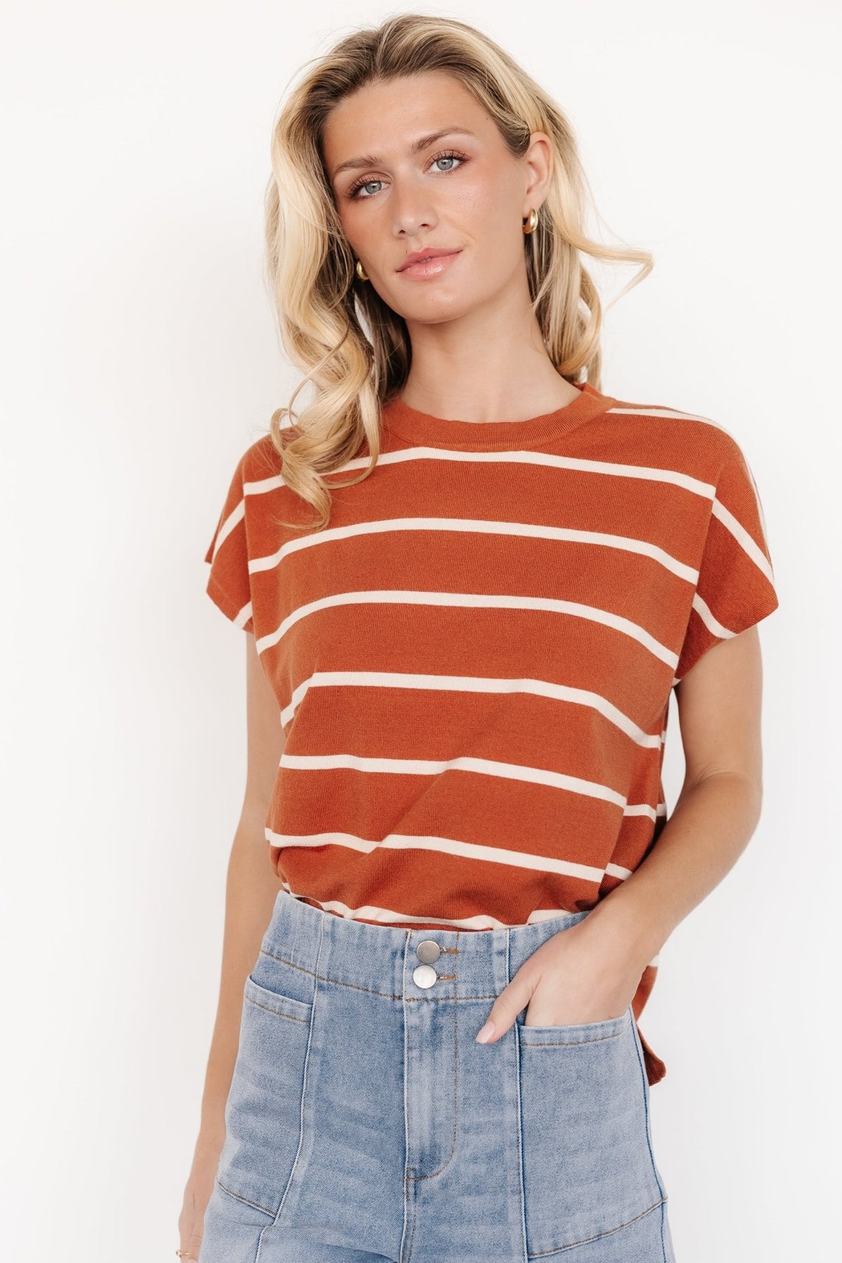 Model wearing Ada Dolman top in sandstone and natural stripes; relaxed silhouette and round neckline visible for styling reference.