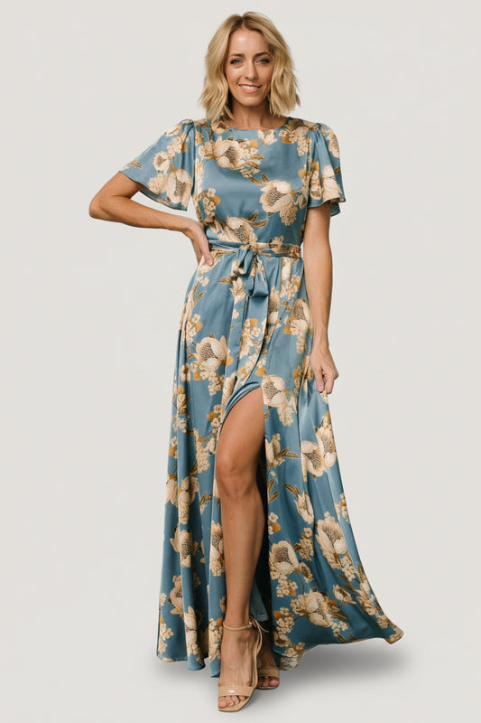 Front view of Agnes satin maxi dress in vintage teal with gold floral print, rounded neckline, removable waist tie and left leg slit.