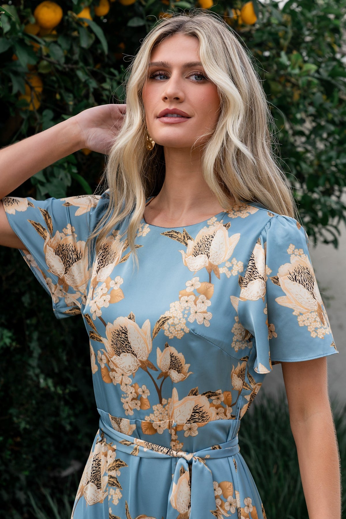 Close-up of Agnes dress fabric highlighting vintage teal satin texture and gold floral pattern with smooth lined body.