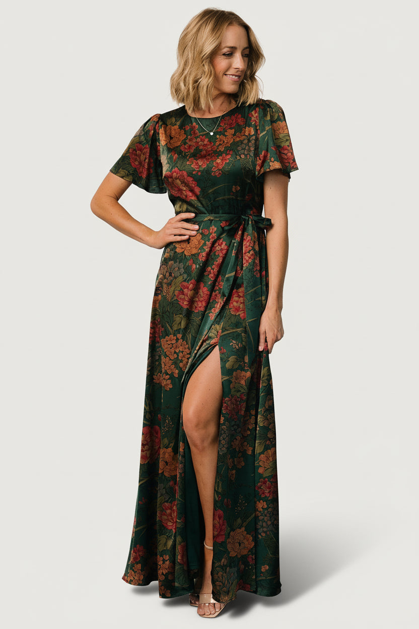 Styled look of dark green floral satin maxi dress paired with neutral heels, showing how the removable tie shapes the waist.