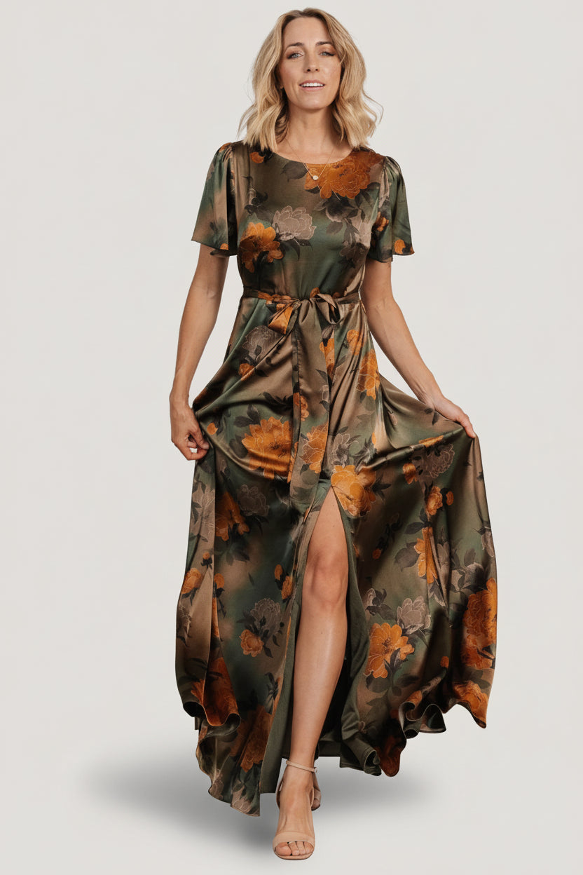 Studio shot of the olive floral satin maxi dress on a neutral background showing full length and sleeve silhouette.