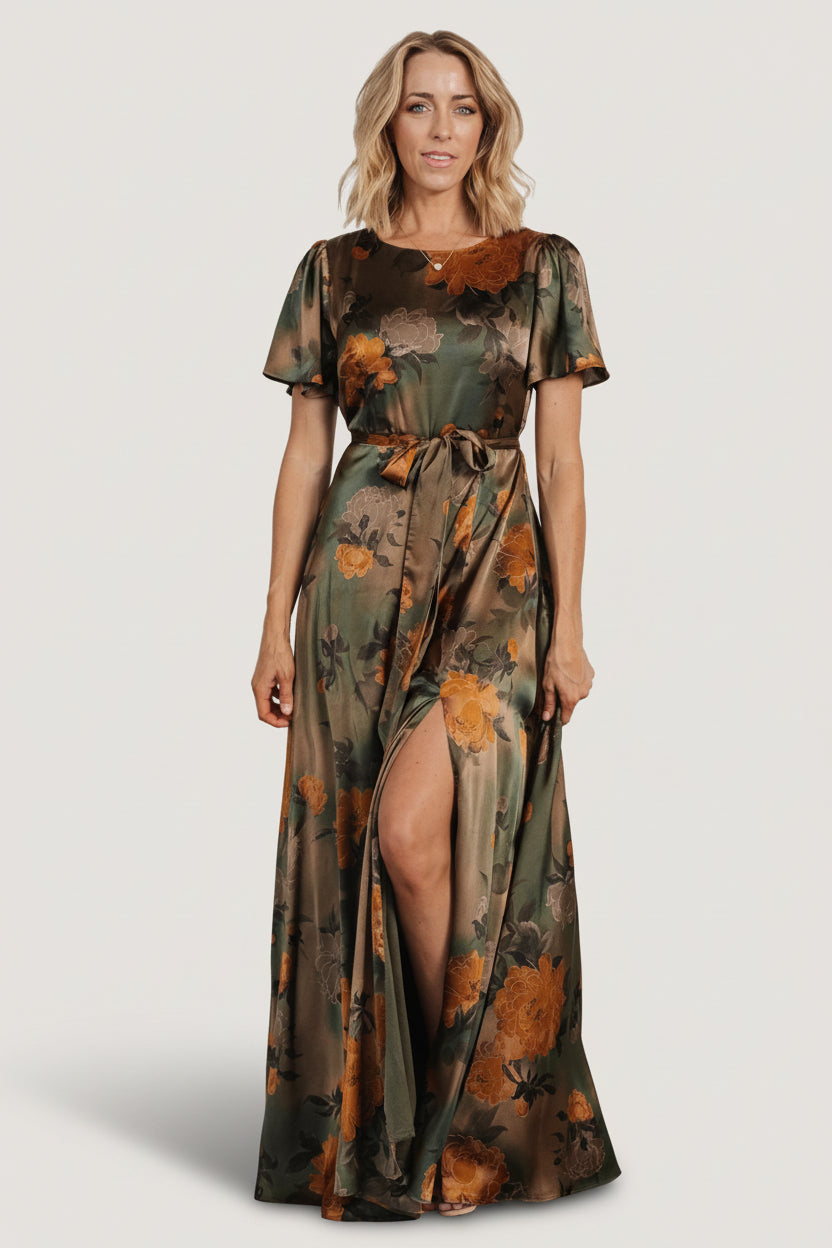 Front full-length view of olive floral satin maxi dress with rounded neckline, flutter sleeves, removable sash, and flowing skirt.