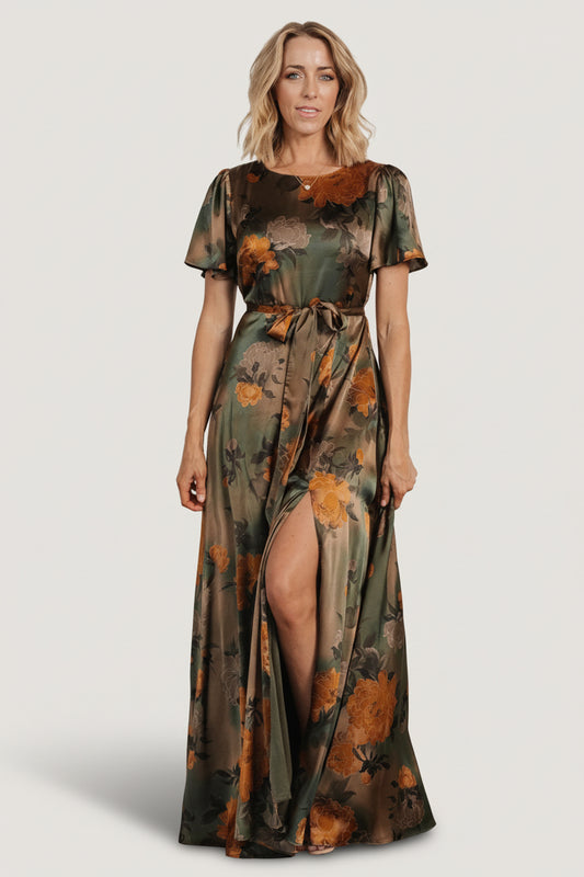 Front full-length view of olive floral satin maxi dress with rounded neckline, flutter sleeves, removable sash, and flowing skirt.