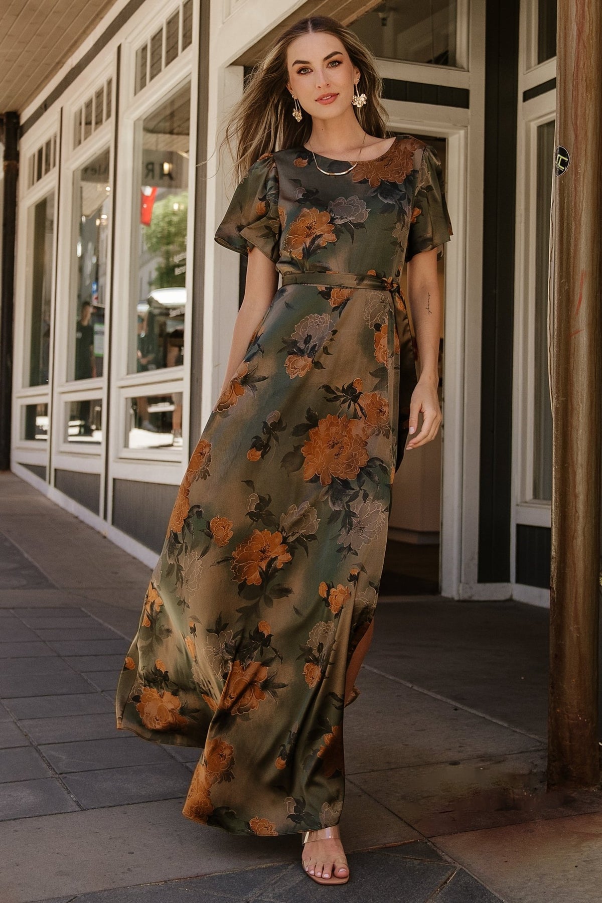 Back view of olive floral satin maxi dress highlighting keyhole button at back neck and elastic back waist for flexible fit.