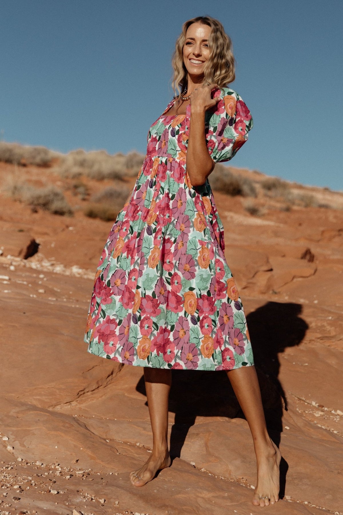 Full-length shot of the Aimee midi dress in pink multi, highlighting the lined midi skirt, mid-calf length and vibrant all-over floral pattern.